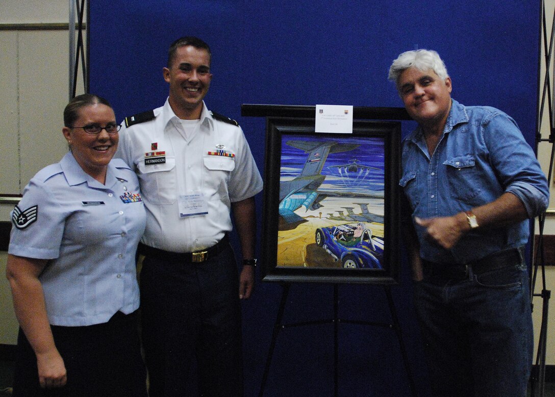 (From left to right) Air Force Staff Sgt. Allison Hermanson, her husband Army 1st Lt. Kyle Hermanson and TV host and comedian, Jay Leno, pose for a photo around the painting entered by Lt. Hermanson for the 433rd Airlift Wing's Jay Leno Art Contest, Aug. 6, 2011, at the Kelly Field Club at Port San Antonio. The Army officer took first place in the art competition. He is currently a member of the 69th Air Defense Brigade at Ft. Hood, Texas and his wife is a member of the 433rd Aeromedical Evacuation Squadron, an Air Force Reserve unit at Lackland Air Force Base, Texas.  (U.S. Air Force photo/Senior Airman Brian McGloin) 