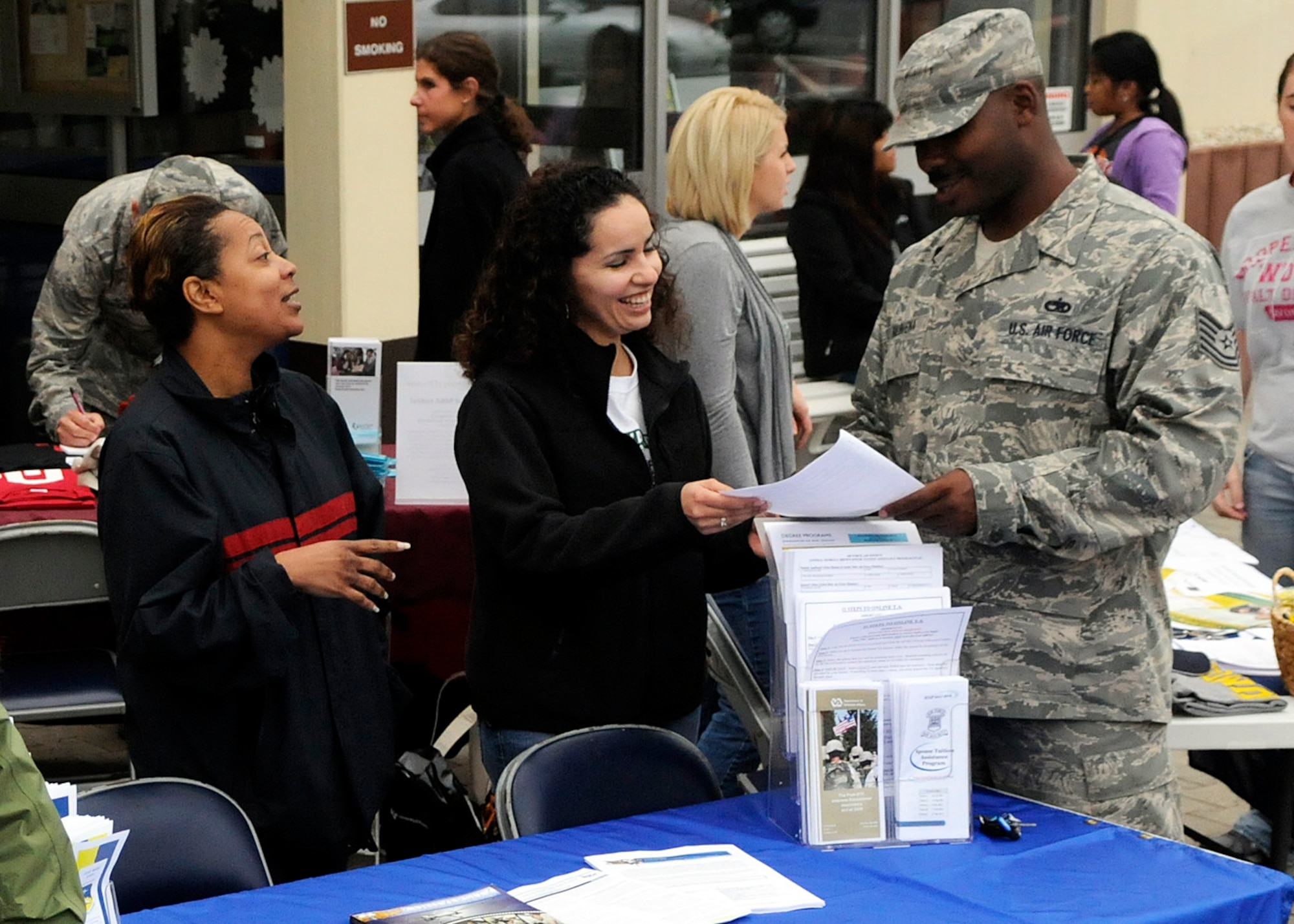 SPANGDAHLEM AIR BASE, Germany -- Sylvia Tompkins-Parker and Judy Garcia, both representatives from Community College of the Air Force, speak with Tech. Sgt. Frank Balbuena, 52nd Equipment Maintenance Squadron, during an education fair and cookout in front of the commissary here Aug. 12. More than 200 Airmen participated in the event, which provided information on the upcoming college semester, available classes and general education concerns. (U.S. Air Force photo/Senior Airman Daryl Knee)