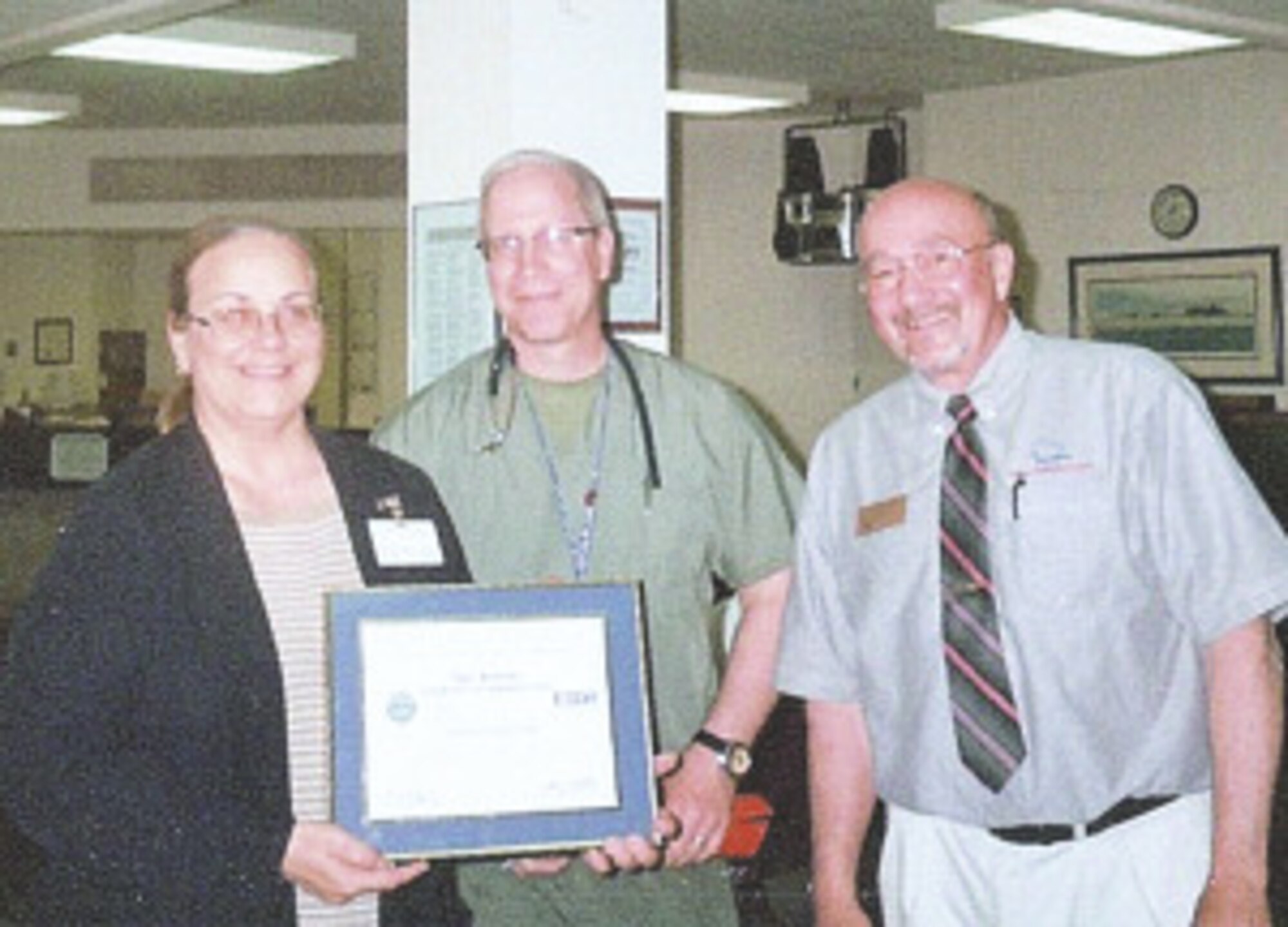 Staff Sgt. Thomas Garvey, center, a nurse at the Twin Ports Veterans Outpatient clinic, nominates his boss, Mary Kolosky, left, for the Employer Support of the Guard and Reserve Patriotic Employer award, presented by Terry Erickson, an ESGR volunteer, right. (Submitted photo)