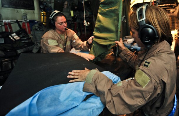 Capt. Christy Livery, 379th Expeditionary Aeromedical Evacuation Squadron medical crew director, and Master Sgt. Jennifer Wilson, 379th EAES aeromedical evacuation technician, prepare a litter for a patient on a C-130 Hercules prior to an aeromedical evacuation mission on Aug. 6, 2011. Livery is deployed from Scott Air Force Base, Ill., and Wilson is deployed from Peterson Air Force Base, Colo. (U.S. Air Force photo/Senior Airman Paul Labbe)