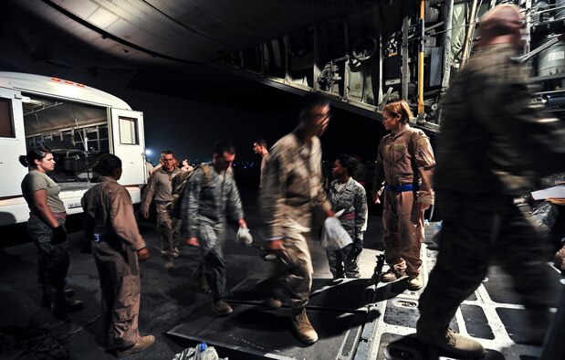Staff Sgt. Erika Archer, 379th Expeditionary Aeromedical Evacuation Squadron duty controller, and Capt. Christy Livery, 379th EAES medical crew director, direct passengers and patients onto a C-130 Hercules, Aug. 6, 2011, at an undisclosed location in Southwest Asia. Archer is deployed from Pope Field, N.C., and Livery is deployed from Scott Air Force Base, Ill. (U.S. Air Force photo/Senior Airman Paul Labbe) 