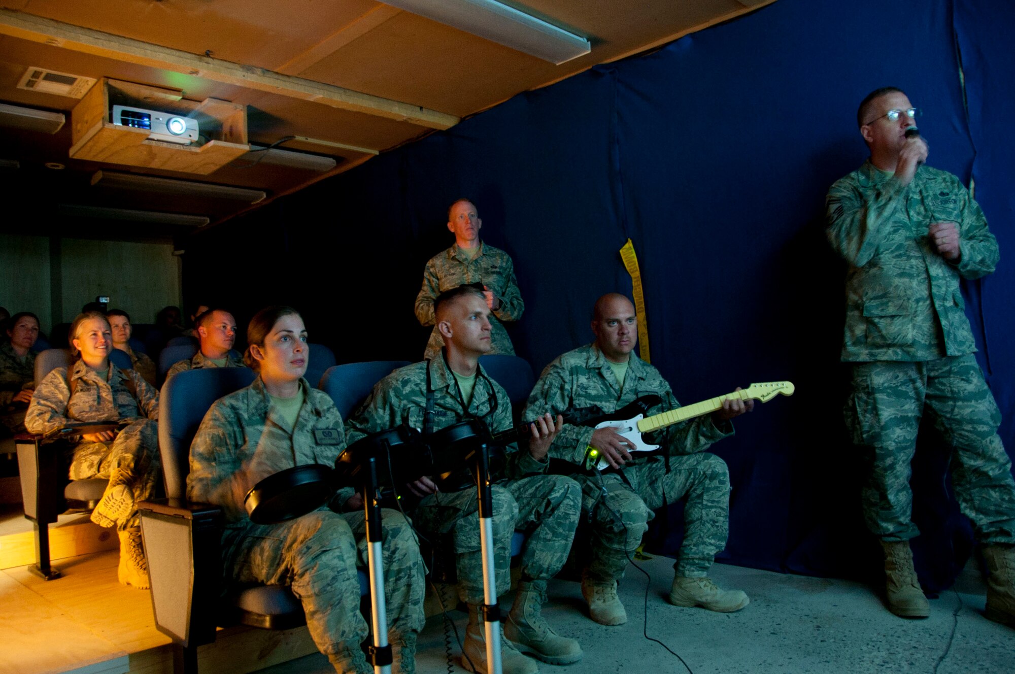 (From front left) Airman 1st Class Andrea Falkenburg, 777th Expeditionary Prime BEEF Squadron structures journeyman, Master Sgt. Brian Feldhouse, 451st Expeditionary Force Support Flight manpower analyst and acting services superintendent, Staff Sgt. Bryan Bleish, 777th Expeditionary Prime BEEF Squadron structures craftsman, and Senior Master Sgt. Robert Castor, 451st Expeditionary Force Support Flight services superintendent, play "Rock Band" in the new theater inside Camp Samek's Recreation Center at Kandahar Airfield, Afghanistan, Aug. 13, 2011. The recreation center hosts many events including dinner and a movie every Saturday night. (U.S. Air Force photo by Senior Airman Corey Hook)