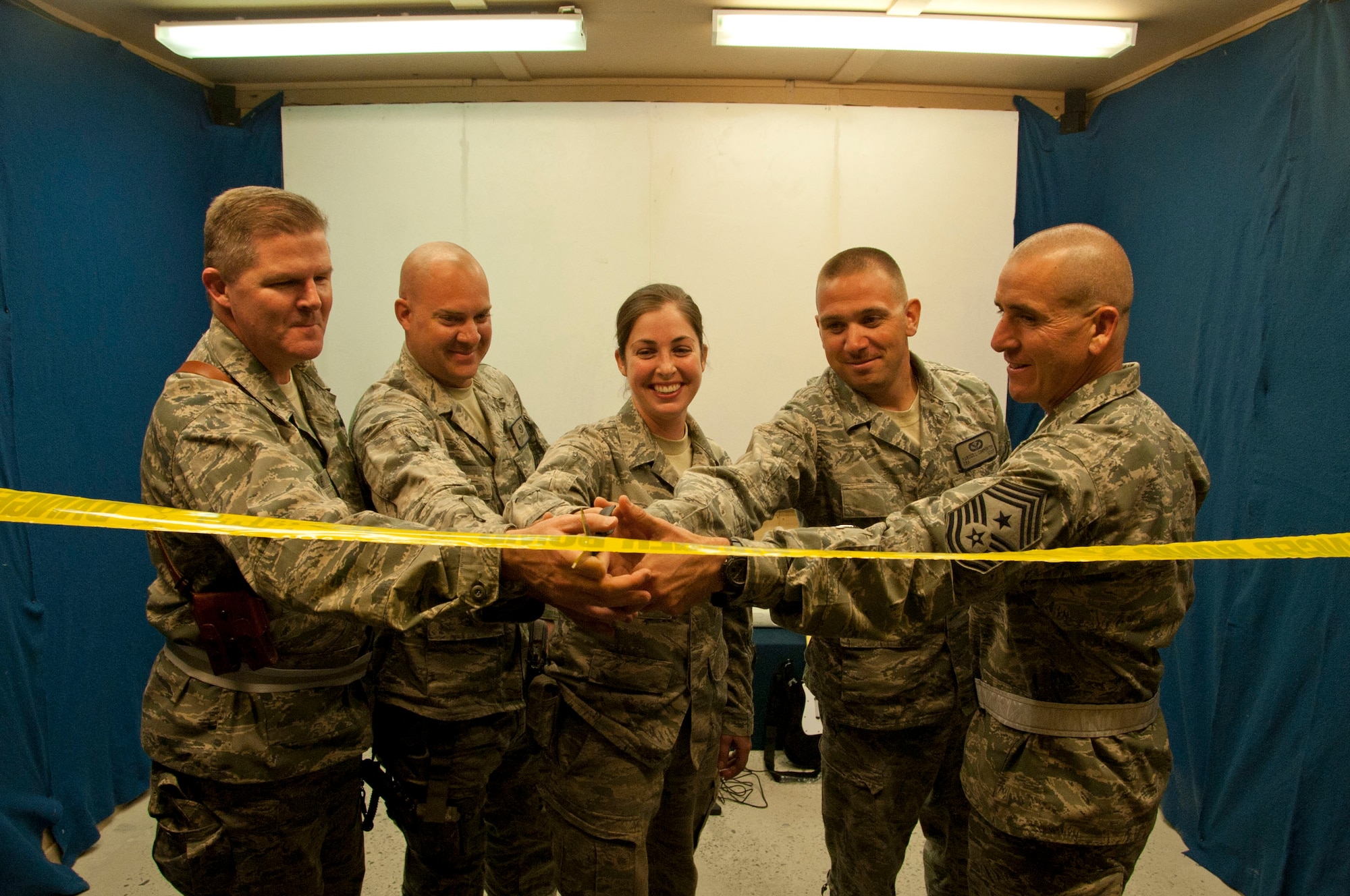 Brig. Gen. Thomas Deale, 451st Air Expeditionary Wing commander, and Chief Master Sgt. Thomas Vallely, 451st Air Expeditionary Wing command chief, accompany (from left) Staff Sgt. Bryan Bleish, Airman 1st Class Andrea Falkenburg and Senior Airman Marcus Carpenter, 777th Expeditionary Prime BEEF Squadron structures flight members, cut the ribbon to signify the opening of the new theater inside Camp Samek's Recreation Center at Kandahar Airfield, Afghanistan Aug. 13, 2011. Bleish, Falkenburg and Carpenter, who are all assigned to Peterson Air Force Base, Colo., worked together to build the new theater. (U.S. Air Force photo by Senior Airman Corey Hook)