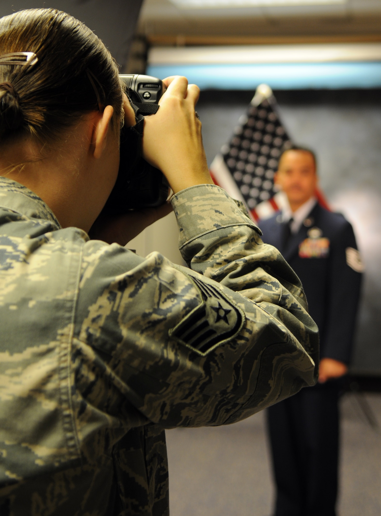 RAF MILDENHALL, England – Staff Sgt. Tabitha Lee, 100th Air Refueling Wing Public Affairs photographer, takes a studio photo here Aug. 15, 2011 during the new studio walk-in hours. Walk-in appointments for head and shoulders photos are available Mondays from 8 to 11 a.m. and 1 to 4 p.m. Official photos can be taken on Tuesdays and Thursdays, by appointment only. Full-length photos are only offered Thursday afternoons. (U.S. Air Force photo/Senior Airman Rachel Waller)