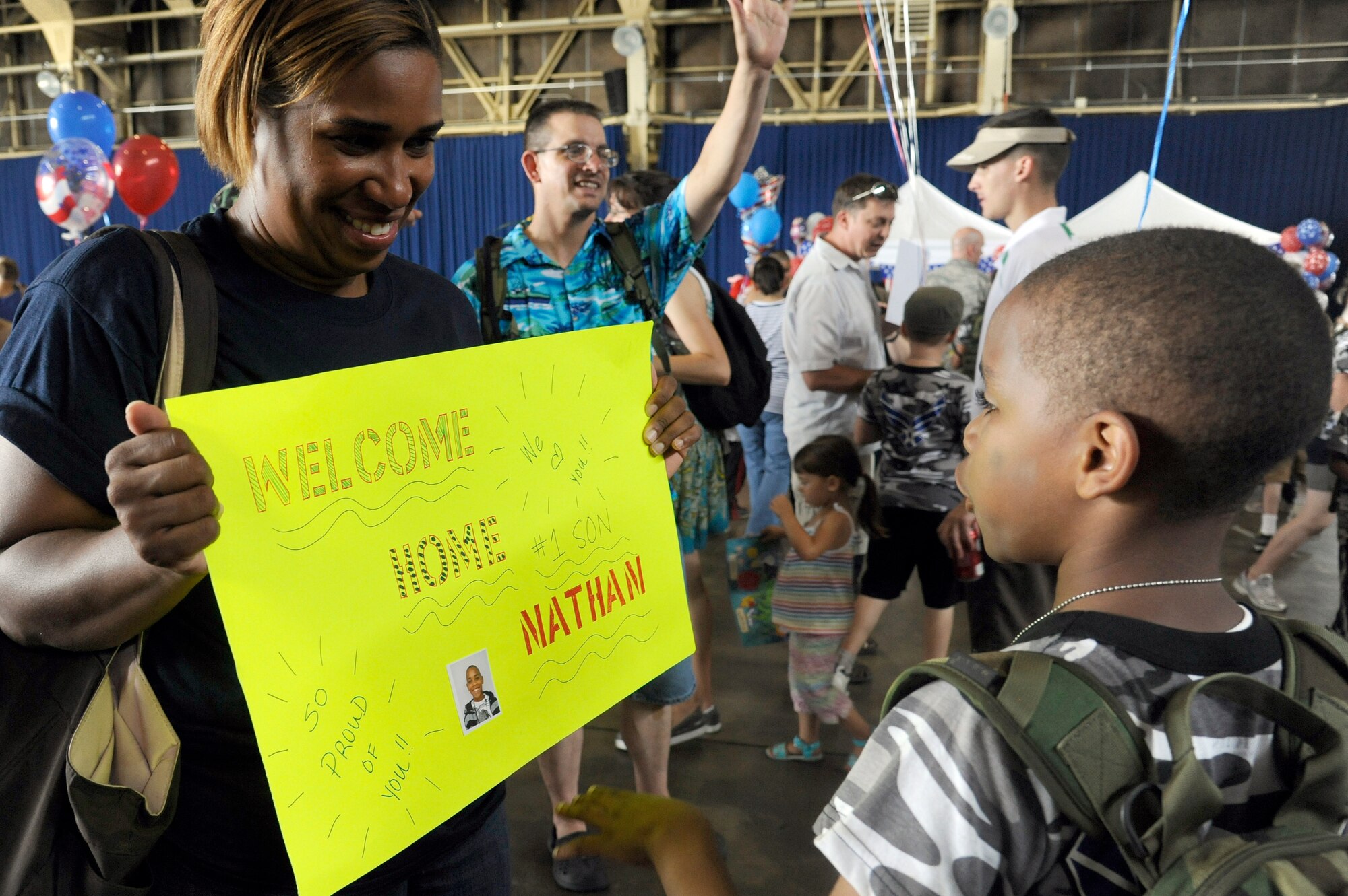 MISAWA AIR BASE, Japan -- Trisha Mickles, left, shows her son Nathan, his welcome home sign during Operation Children on Deployment Exercise Aug. 13. The children were welcomed home with signs, balloons and cake at the end of their simulated deployment. (U.S. Air Force photo/Tech. Sgt. Marie Brown)