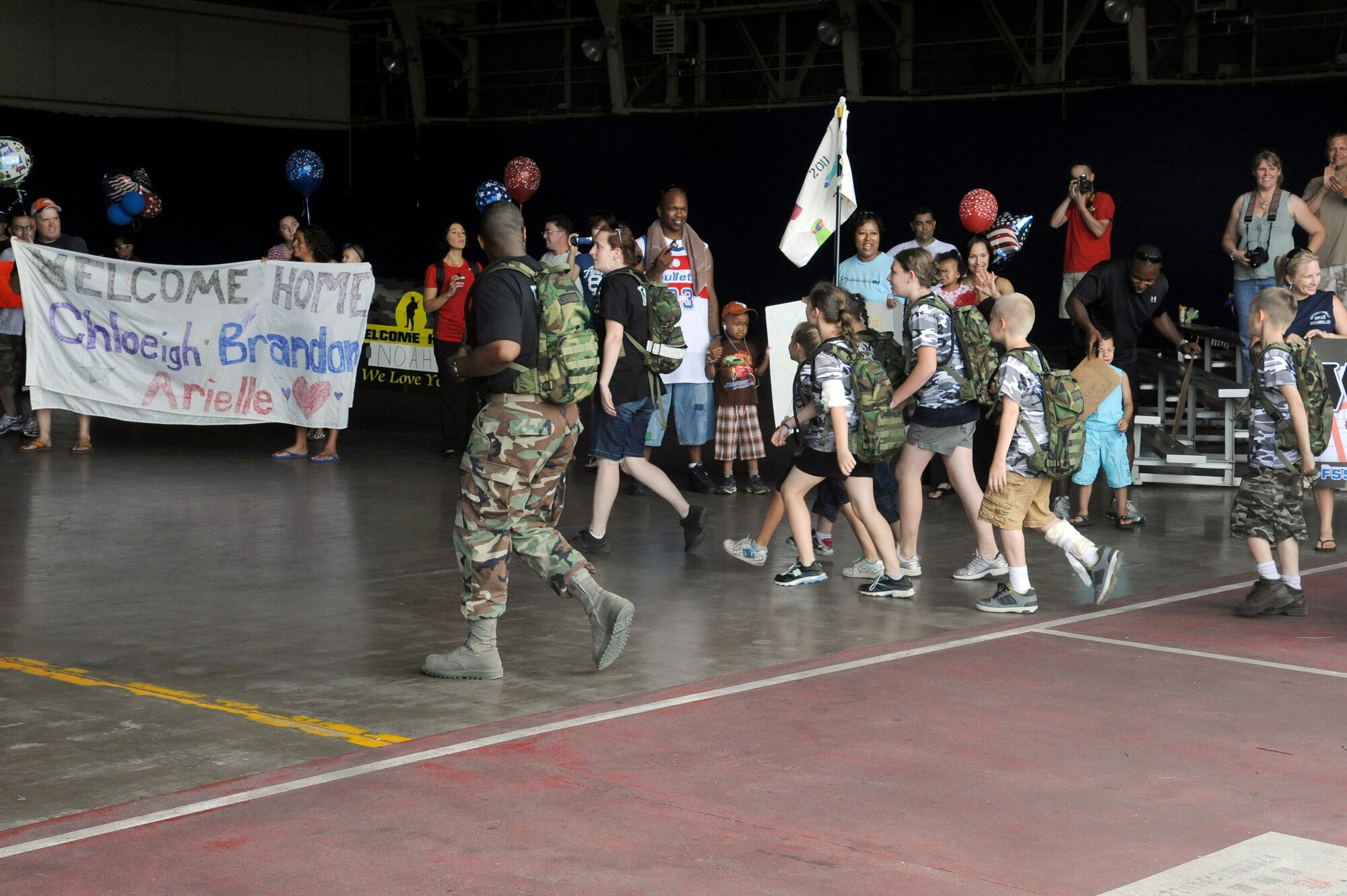 MISAWA AIR BASE, Japan -- Moms, dads, brothers and sisters welcome home their loved ones after their simulated deployment to Camp Defender during Operation Children on Deployment Exercise Aug. 13.  More than 150 children processed through the deployment line to have the opportunity to walk in their parents shoes. (U.S. Air Force photo/Tech. Sgt. Marie Brown)