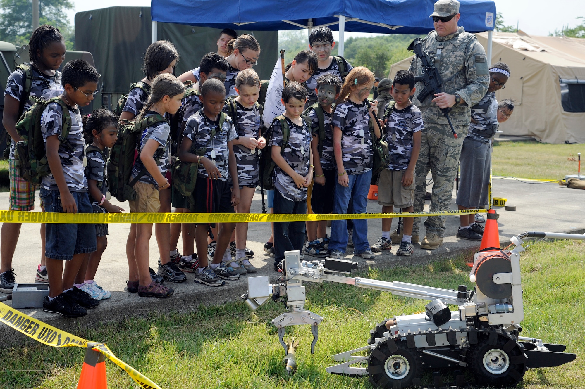 MISAWA AIR BASE, Japan -- Children watch an Explosive Ordnance Disposal demonstration during Operation Children on Deployment Exercise at Camp Defender Aug. 13. Each child was given self-defense and fire training, along with a chance to see a Security Forces K-9 demonstration while at Camp Defender. (U.S. Air Force photo/Tech. Sgt. Marie Brown)