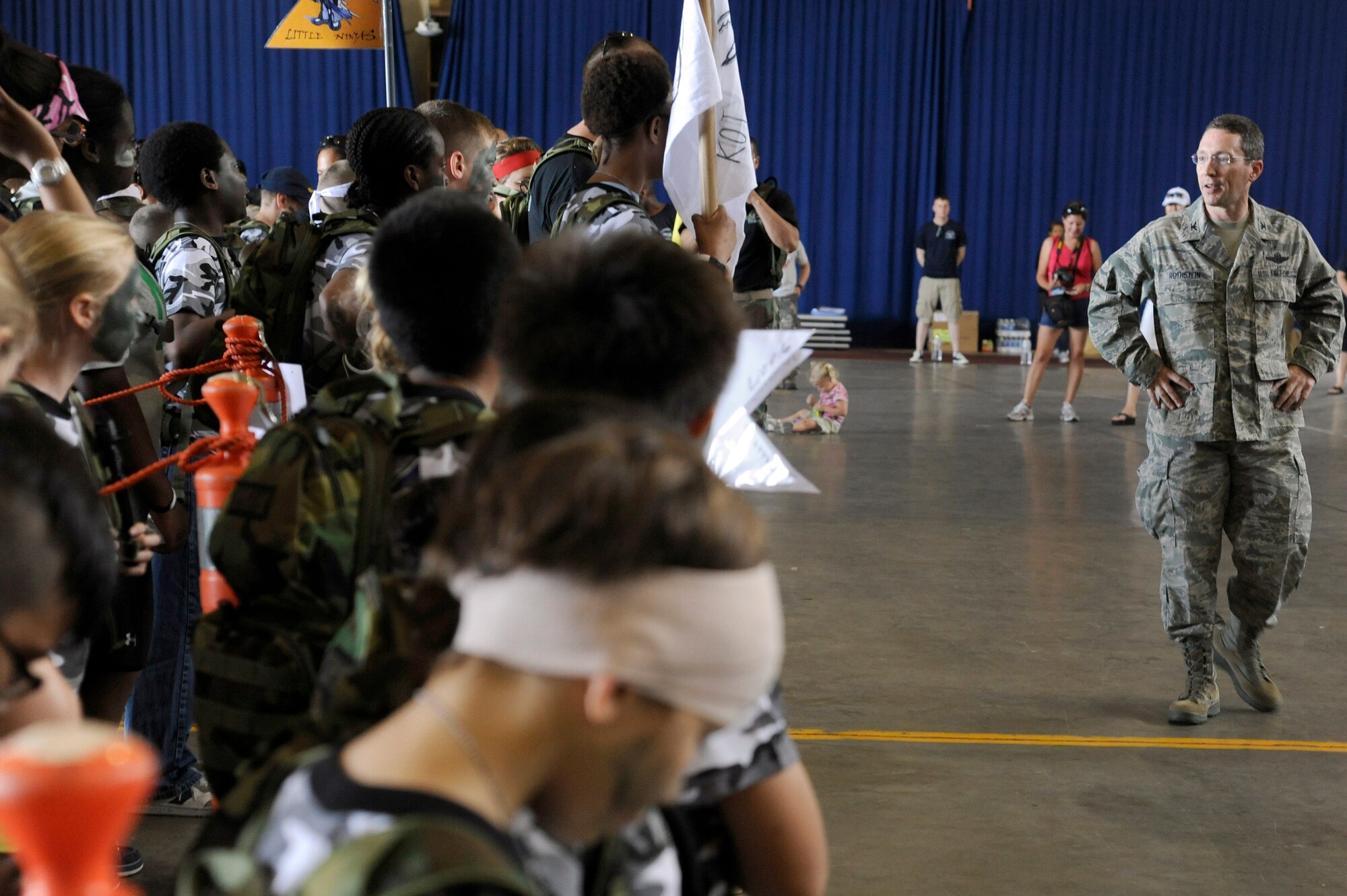 MISAWA AIR BASE, Japan -- Col. Michael Rothstein, right, 35th Fighter Wing commander, gives some encouraging words to the new recruits during Operation Children on Deployment Exercise Aug. 13. After the children processed through the deployment line they were bussed to Camp Defender for more deployment training and fun. (U.S. Air Force photo/Tech. Sgt. Marie Brown)