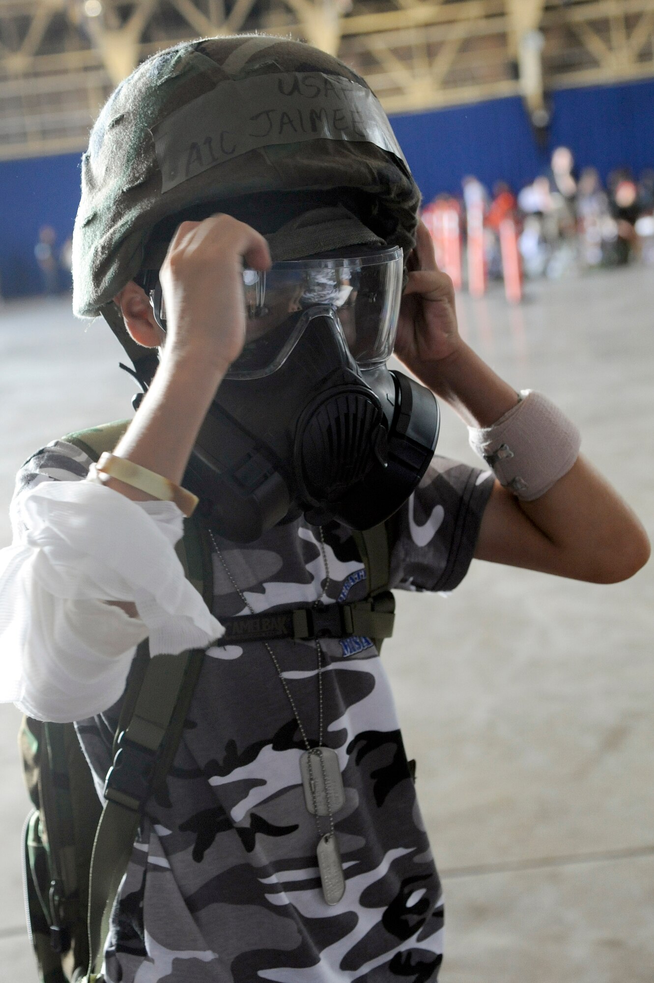 MISAWA AIR BASE, Japan -- Christian Colburn, son of Tech. Sgt. Shawn Colburn, 35th Maintenance Squadron, tries on a gas mask and Kevlar helmet during Operation Children on Deployment Exercise Aug. 13th. Children were given the opportunity to try on various pieces of chemical gear as part of the processing line. (U.S. Air Force photo/Tech. Sgt. Marie Brown)