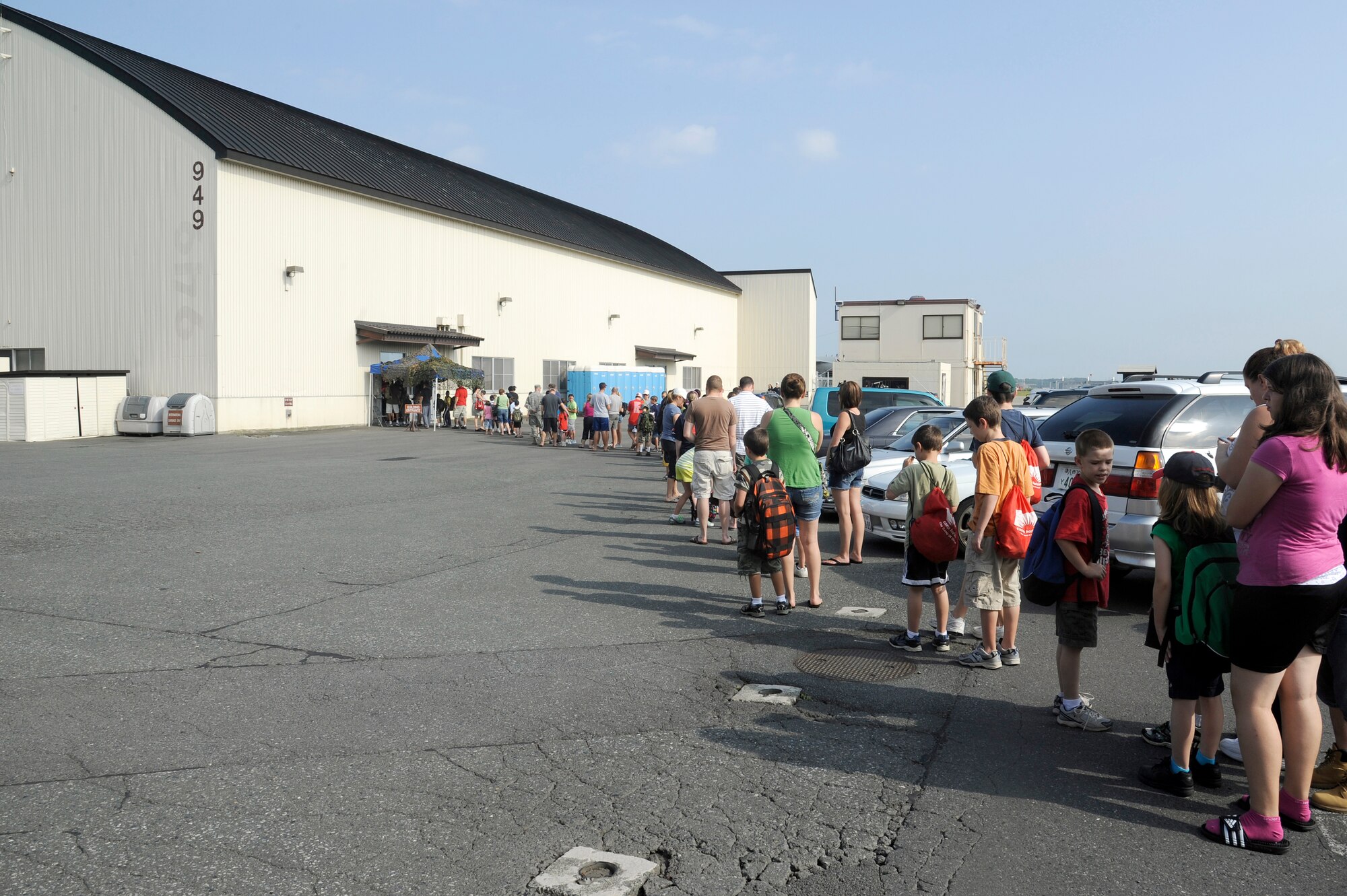 MISAWA AIR BASE, Japan -- Parents line-up with their children outside hangar 949 as they wait to process through the deployment line for Operation Children on Deployment Exercise Aug. 13. More than 150 children processed through the deployment line to have the opportunity to walk in their parents shoes.  (U.S. Air Force photo/Tech. Sgt. Marie Brown)