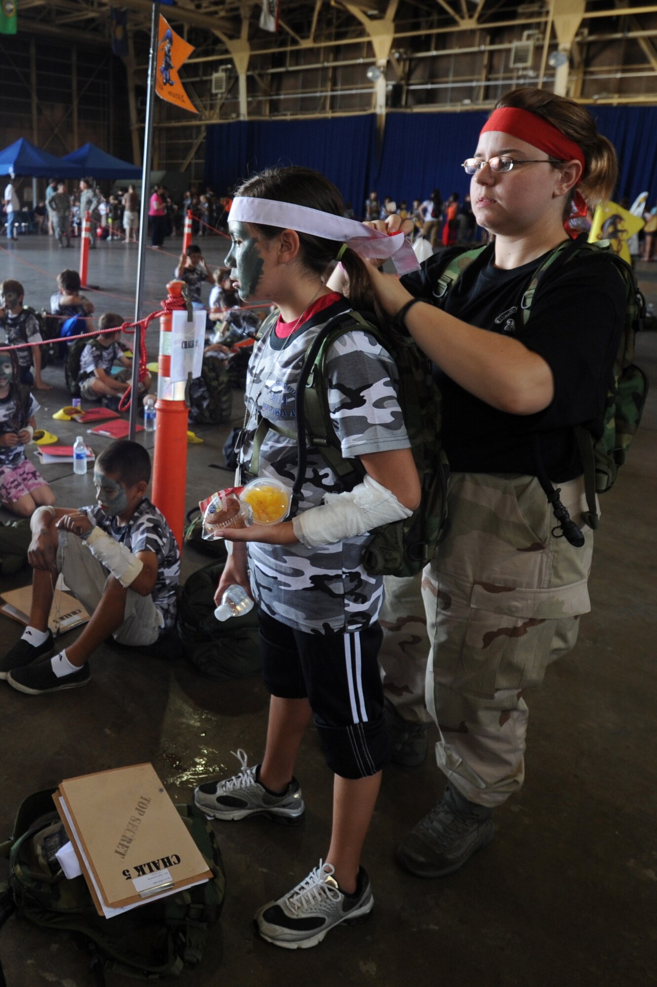 MISAWA Air Base, Japan -- Natasha Biquet, right, welcomes a child to Chalk 5 "The Little Ninjas" by tying on a head band during Operation Children on Deployment Exercise Aug. 13.  Members of Misawa Air Base volunteered to be Military Training Leaders for more than 150 children during Operation CODE.   (U.S. Air Force photo/Staff Sgt. April Quintanilla)