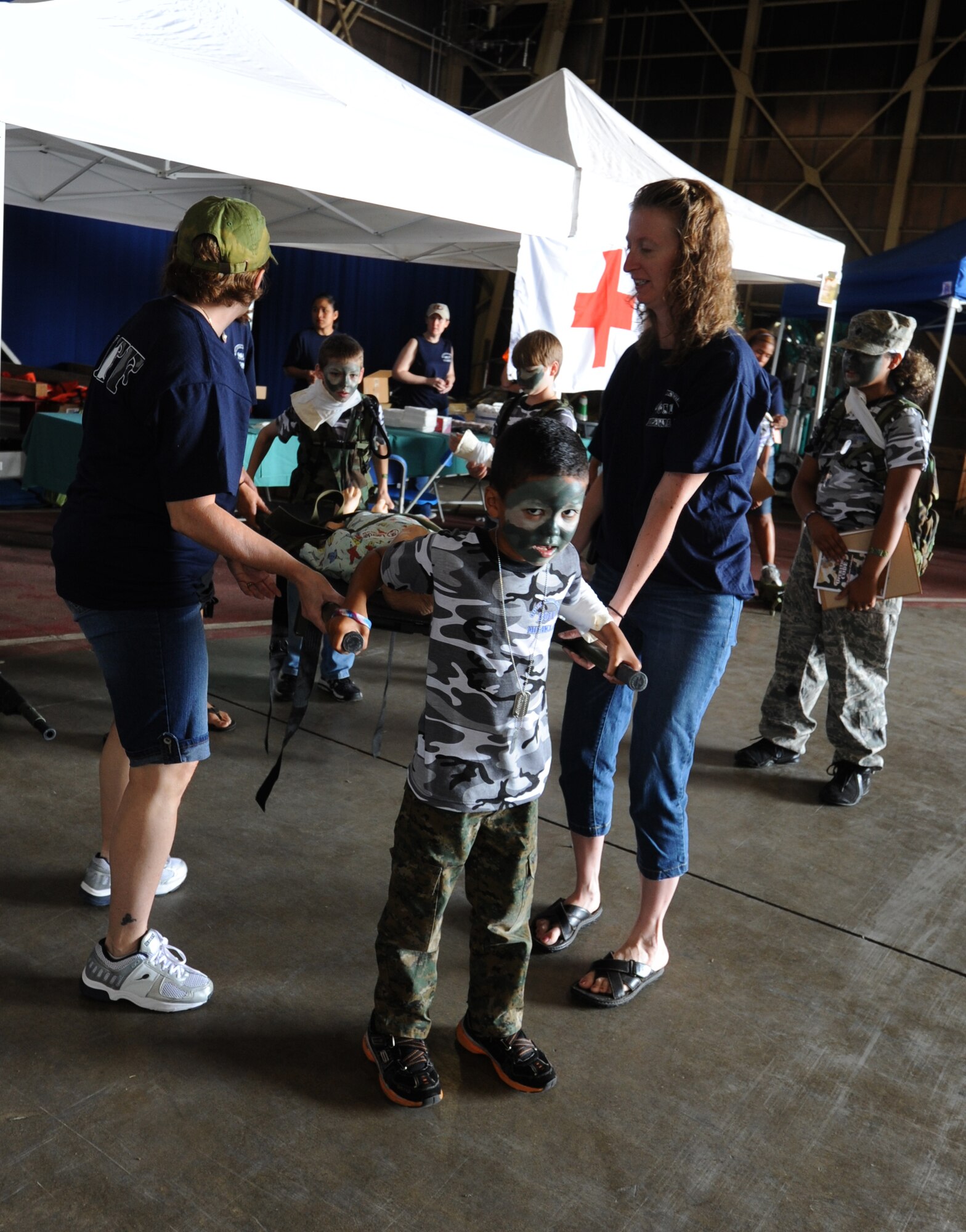 MISAWA Air Base, Japan -- Sammy Lopizich, son of Staff Sgt. April Quintanilla, 35th Fighter Wing Staff, front, and Parker Kelley, son of Airman 1st Class Shawn Kelley, 35th Civil Engineer Squadron, back, learn how to lift and carry an injured person on a litter.  Sammy participated in Operation Children on Deployment Exercise 2011 along with more than 150 other children.   (U.S. Air Force photo/Staff Sgt. April Quintanilla)