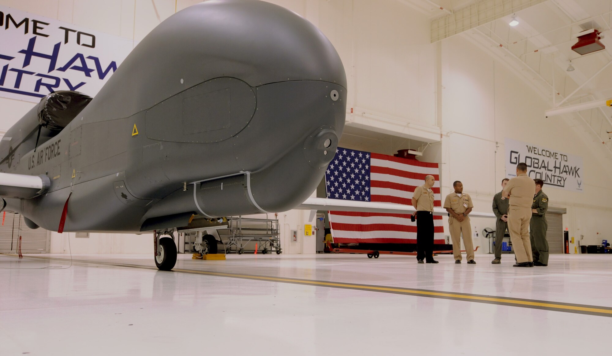 ANDERSEN AIR FORCE BASE, Guam – The RQ-4 Global Hawk aircrafts sets in a hanger as U.S. Navy Rear Admiral Paul Bushong, U.S. Naval Forces Marianas commander, visits the 9th Operations Group Det. 3 during his base visit here Aug. 12. The Admiral was given a tour of the detachment to include a walk-through of the Global Hawk hanger. (U.S. Air Force photo by Senior Airman Benjamin Wiseman/Released)