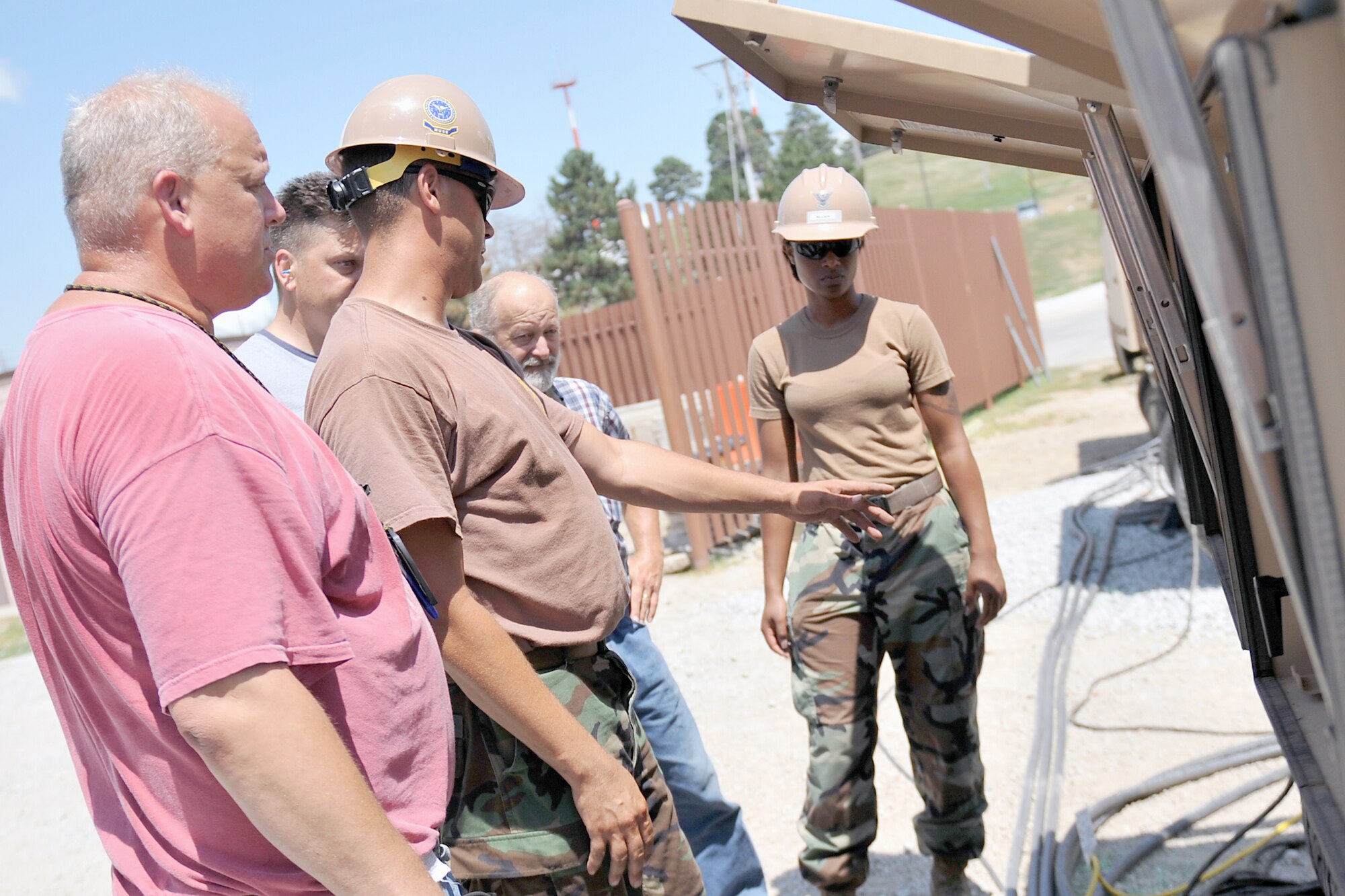 Petty Officer 1st Class Eric Sanders, a utilitiesman with a Mobile Utilities Support Equipment team from Port Hueneme, Calif., shows power production technicians from the 55th Civil Engineer Squadron here how to operate one of their generators as Petty Officer Second Class Jodi-Ann Allen, a construction electrician, watches on July 19 at Offutt Air Force Base, Neb. The MUSE team was here from July 18-27 to install a 3.2 megawatt power plant in conjunction with a 5000 KVA substation. (Air Force photo by Jeff Gates)