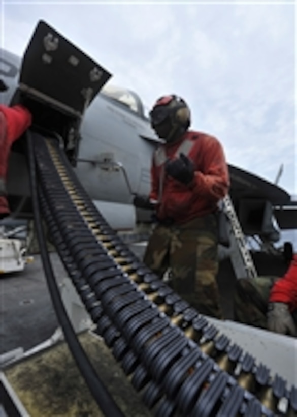 Petty Officer 3rd Class Christian Jones uses a speed wrench to load 20mm high explosive incendiary rounds into an F/A-18E Super Hornet assigned to Strike Fighter Squadron 115 aboard the aircraft carrier USS George Washington (CVN 73) in the South China Sea on Aug. 11, 2011.  The George Washington departed its forward-operating base of Fleet Activities Yokosuka on June 12, 2011, to patrol the U.S. 7th Fleet area of responsibility.  