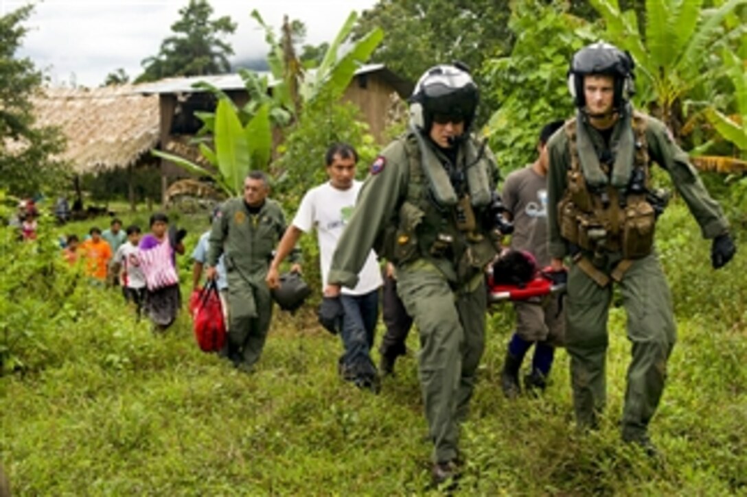 U.S. Navy Chief Justin Crowe (left) and Petty Officer 3rd Class Joe Wainscott and villagers carry an injured boy toward an MH-60S Sea Hawk helicopter during Continuing Promise 2011 in Bajo Blay, Costa Rica, on Aug. 10, 2011.  Crowe and Wainscott are assigned to Helicopter Sea Combat Squadron 26.  Continuing Promise is a five-month humanitarian assistance mission to the Caribbean, Central and South America.  