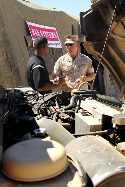 Brig. Gen. John Broadmeadow, Deputy Commander, Marine Forces Pacific, listens to information about a high capacity alternator from one of several vendors during the Experimental Forward Operating Base 2011 at Marine Corps Air Ground Combat Center Aug. 16, 2011. The alternator, used with vehicles that require a lot of energy for on-board systems, is one of the renewable energy products showcased.