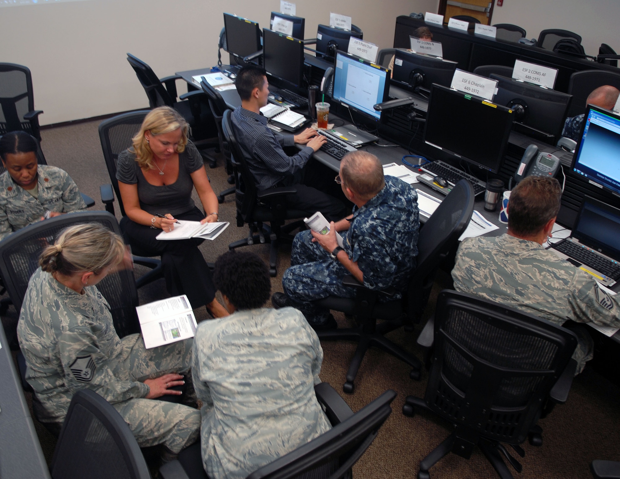 Members of the Joint Base Pearl Harbor-Hickam Emergency Operations Center review a scenario during training Aug. 11. This training, the first since the installation joint based, will ensure the IMT members know exactly what to do in case of emergency. (U.S. Air Force photo/Staff Sgt. Carolyn Herrick)
