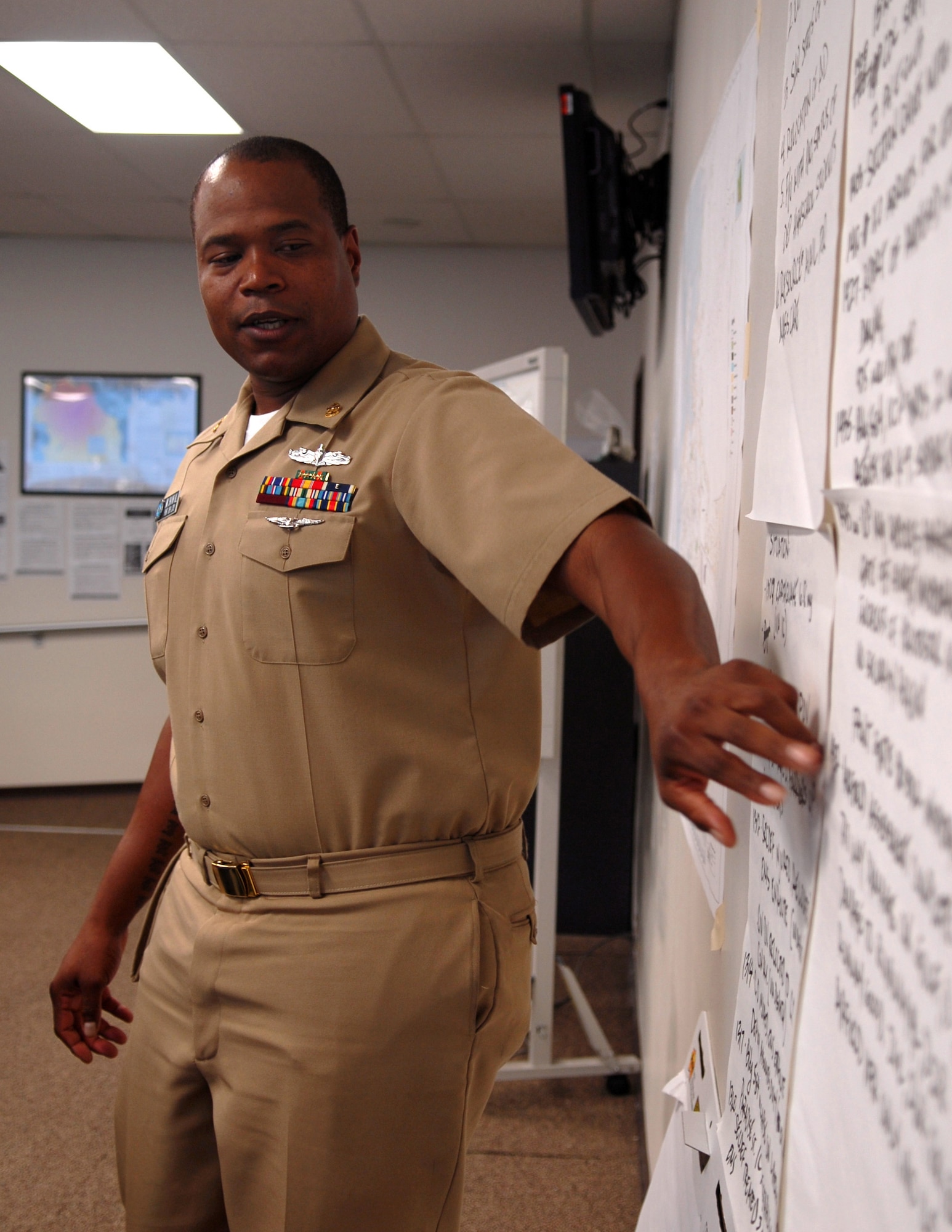Boatswain's Mate Travis Hall, Joint Base Pearl Harbor-Hickam port operations dock master, gives a situation briefing in the Emergency Operations Center here Aug. 11. Twenty-eight members of the EOC participated in incident management team training, including earthquake and flood drill scenarios, Aug. 9 to 12 in compliance with the Homeland Presidential Security Declaration 5, which dictates that all Federal agencies and entities that receive funding be compliant with certain procedures. (U.S. Air Force
photo/Staff Sgt. Carolyn Herrick)
