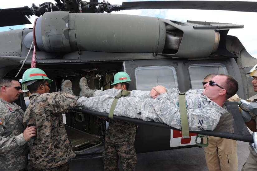 Honduran and Costa Rican firefighters unload Senior Airmen Stephen Cushing, 612th Air Base Squadron firefighter, from a UH-60 helicopter during an exercise at Soto Cano Air Base, Honduras, Aug. 16, 2011. The exercise, called Central America Sharing Mutual Operational Knowledge and Experiences or CENTAM SMOKE, allows U.S. and Honduran Airmen and civilian firefighters four days of team-building training. (U.S. Air Force photo by Tech. Sgt. Matthew McGovern)
