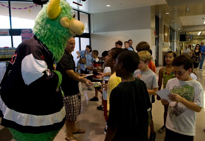 Duke the bull, the Las Vegas Wranglers hockey team mascot, greets children who are donating food Aug. 12, 2011, at the Nellis Air Force Base Commissary.  The base commissary is serving as a collection point for this year's "Feds Feed Families" food drive campaign.  Donations will be accepted until Aug. 31, 2011. (U.S. Air Force photo by Airman 1st Class Matthew Lancaster)