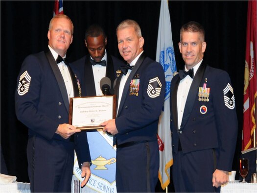 U.S. Air Force Senior Master Sgt. Billie Statom, center, superintendent of the 601st Air and Space Operations Center’s Combat Operations Division, is presented with the distinguished graduate award after completion of the Senior Noncommissioned Officer Academy at Maxwell-Gunter Air Force Base, Ala., July 21. Statom finished the seven-week course, which had 422 students, among the top 10 percent for high academic grades and favorable peer and instructor reviews. (Courtesy photo)