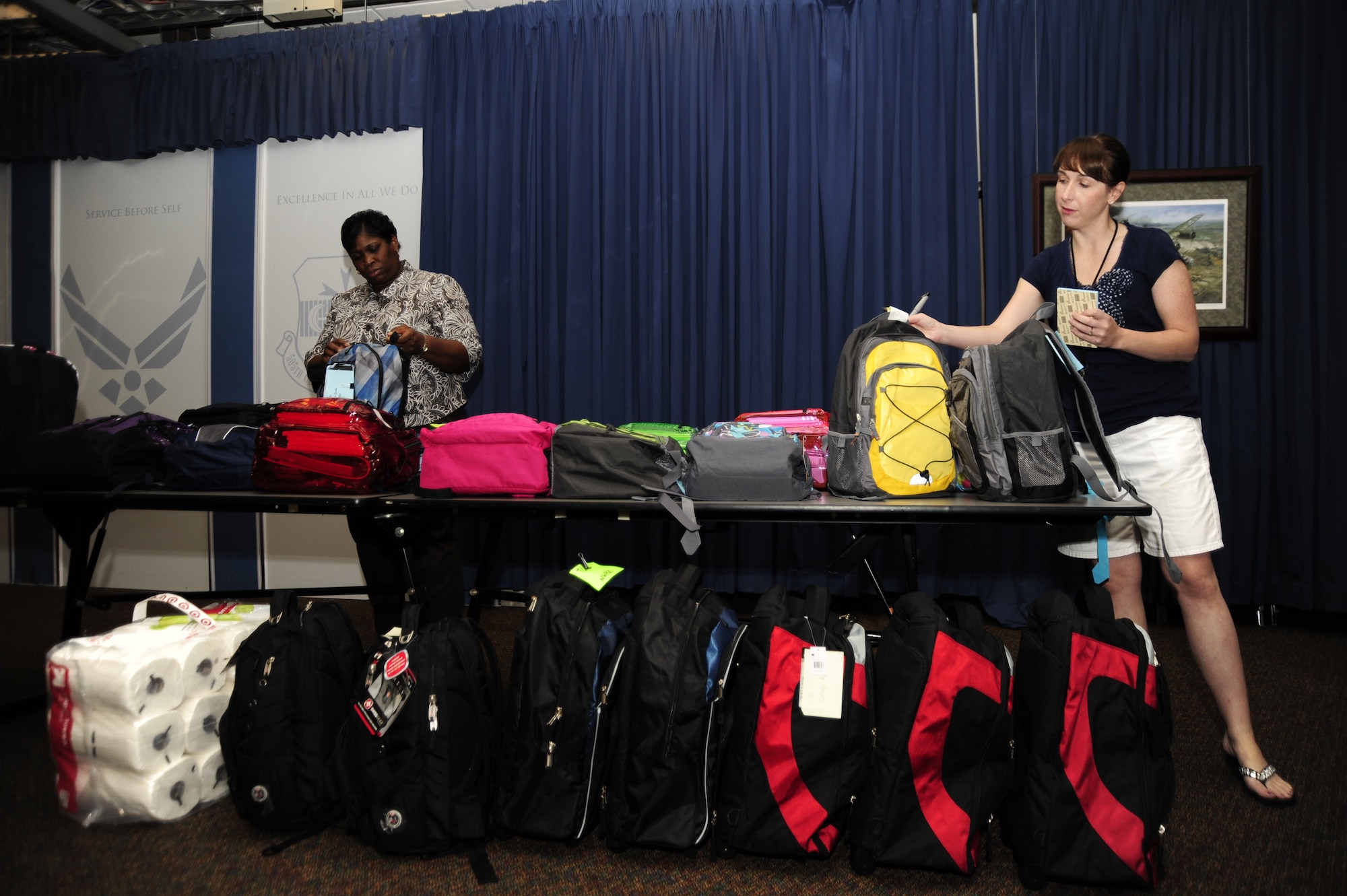 Vanessa Lewis, 505th Communications Squadron plans and programs chief, left, and Tech. Sgt. Angela Whitman, 505th Command and Control Wing training manager, right, check backpacks to ensure they are filled with school supplies at wing headquarters at Hurlburt Field, Fla., August 16, 2011.  505th CCW  Airmen donated school supply kits to children in the local community. (U.S. Air Force photo by Airman Naomi M. Griego)
