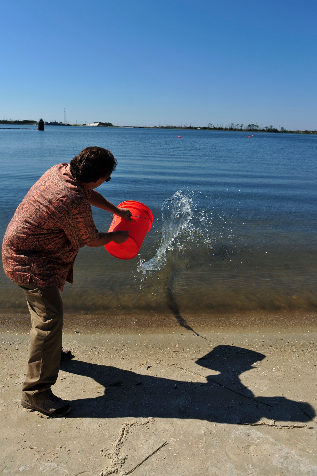 A civilian throws simulated chemical water into the Sound at Hurlburt Field, Fla., Aug. 16, 2011. Illegal dumping and stormwater pollution can have harmful effects on the ecosystem. (U.S. Air Force photo by Staff Sgt. Stephanie Jacobs)