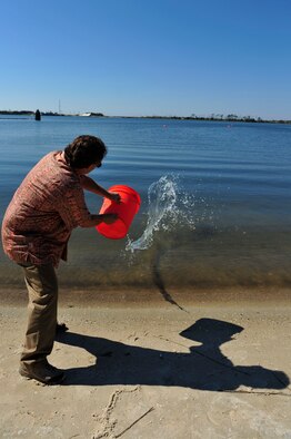 A civilian throws simulated chemical water into the Sound at Hurlburt Field, Fla., Aug. 16, 2011. Illegal dumping and stormwater pollution can have harmful effects on the ecosystem. (U.S. Air Force photo by Staff Sgt. Stephanie Jacobs)
