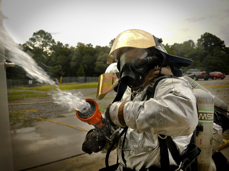 U.S. Air Force Airman 1st Class Elijah Johnson, 23rd Civil Engineer Squadron firefighter, sprays water into a simulated burning building during a phase II operational readiness exercise (ORE) at Moody Air Force Base, Ga., Aug. 16, 2011. Airmen from the 23rd CES partnered in two-man teams to keep a weapons storage building, located next to the burning building, from catching on fire. (U.S. Air Force photo by Airman 1st Class Joshua Green/Released)
