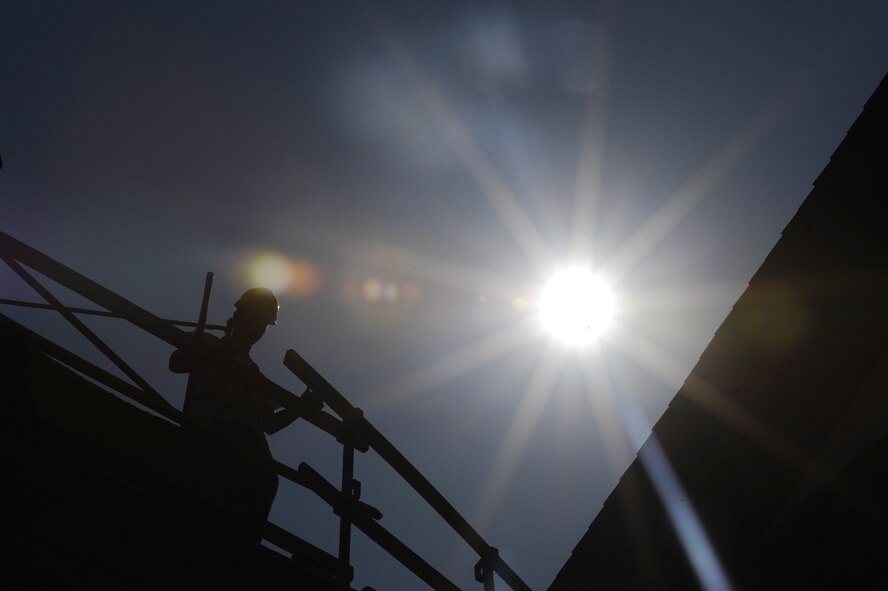 A contractor looks over a rail on top of building 5376 on Barksdale Air Force Base,  La., Aug 16. The 26th Operational Weather Squadron and the 340th Weapons Squadron are scheduled to move into the building once renovations are complete. (U.S. Air Force photo/ Airman 1st Class Micaiah Anthony)(RELEASED)