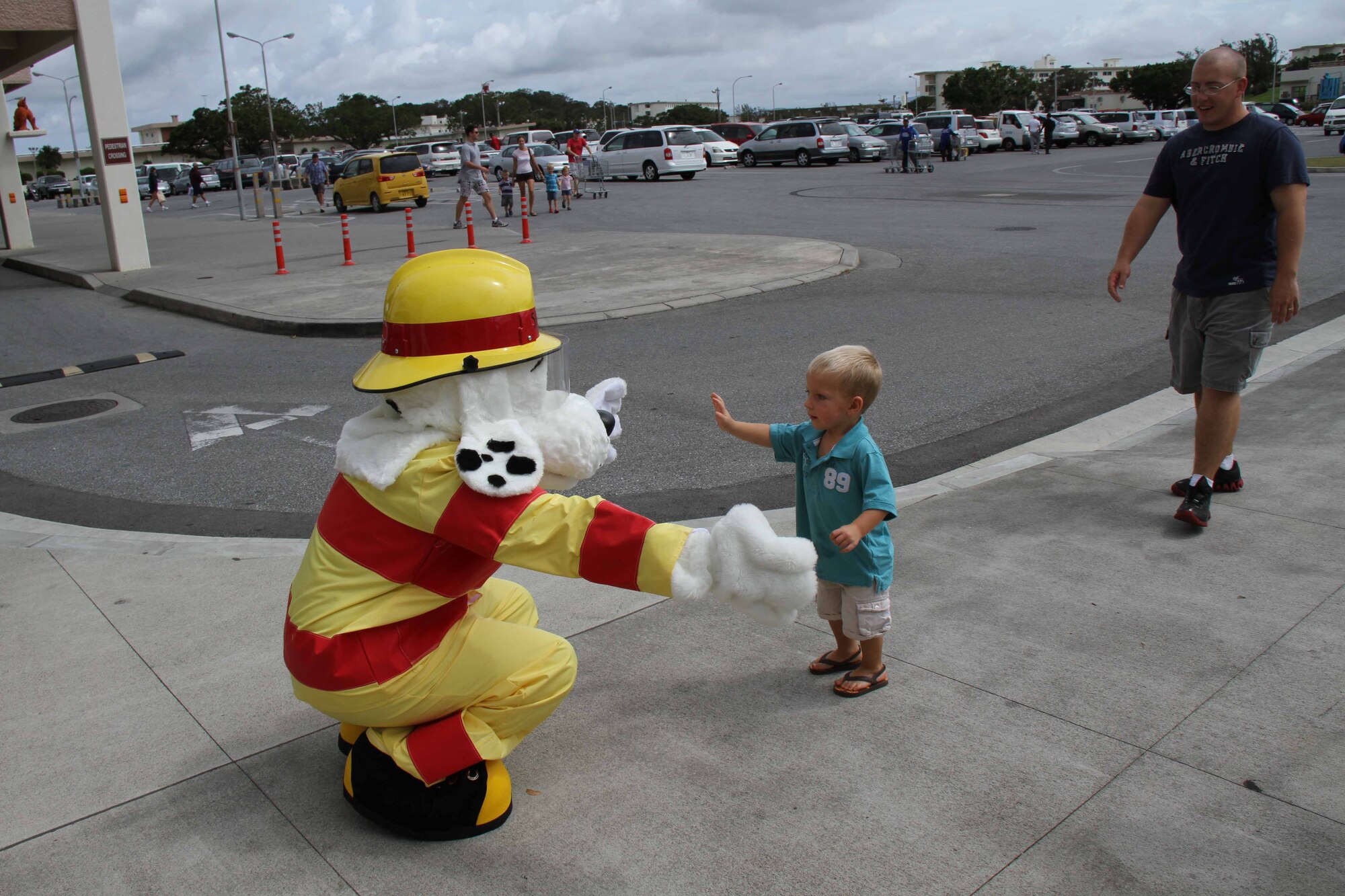 “Sparky the Dog,” the Kadena fire and emergency services mascot, gives a hug to a young member of the Kadena Air Base, Japan, community during the annual “Fill the Boot” Kadena Special Olympics fundraiser outside of the base exchange Aug. 13.  The organization raised over $23,000, more than they have ever risen in this annual charity event. (U.S. Army photo/Charles Steitz)
