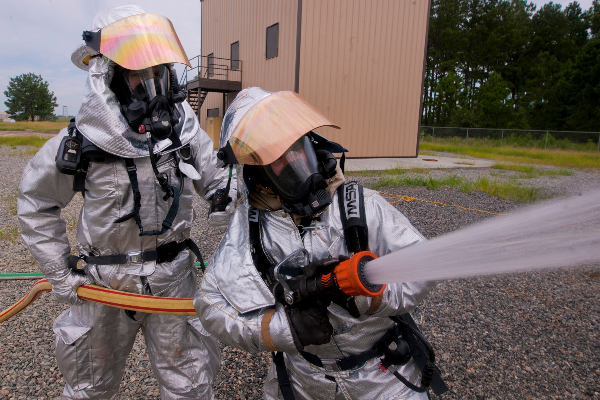 Firefighters from the 23rd Civil Engineer Squadron train on protecting high value objects from surrounding fires during a Phase II operational readiness exercise (ORE) at Moody Air Force Base, Ga., Aug. 16, 2011. Members of Moody participated in the ORE in preparation for an operational readiness inspection scheduled for next year. (U.S. Air Force Photo by Staff Sgt. Joshua J. Garcia/Released)