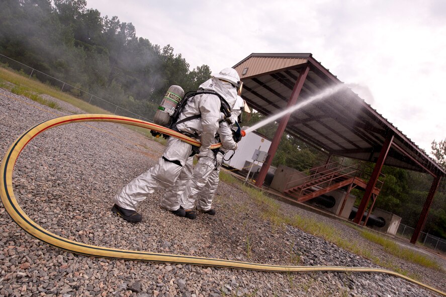 Firefighters from the 23rd Civil Engineer Squadron train on protecting high value objects from surrounding fires during a Phase II operational readiness exercise (ORE) at Moody Air Force Base, Ga., Aug. 16, 2011. The ORE prepares members of Team Moody to operate efficiently in a deployed location. (U.S. Air Force Photo by Staff Sgt. Joshua J. Garcia/Released)