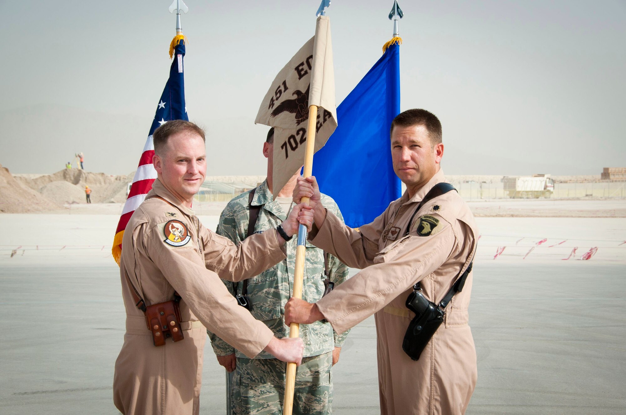 KANDAHAR AIRFIELD, Afghanistan -- Lt. Col. Robert Schuett receives the squadron flag of the 702nd Expeditionary Airlift Squadron during the change of command ceremony and assumes command Aug. 9, 2011. The 702nd EAS is a tactical transport squadron, made up of Army and Air Force Guard flying C-27J Spartans to provide support to Forward Operating Bases. The squadron stood up here July 31. (U.S. Air Force photo by Senior Airman Corey Hook/Released)