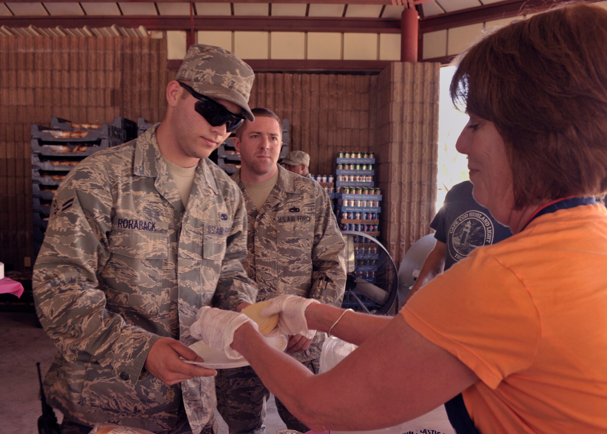 Rosi Cory, Clovis Community College, serves food to Airman 1st Class Shawn Roraback, 27th Special Operations Equipment Maintenance Squadron, at the 22nd annual Cannon Appreciation Day held at Unity Park, Cannon Air Force Base, N.M., Aug. 12, 2011.  The event is sponsored by Clovis, N.M. and local business owners to celebrate and honor the base with prizes, food and visit with one another.  (U.S. Air Force photo by Senior Airman James Bell) 