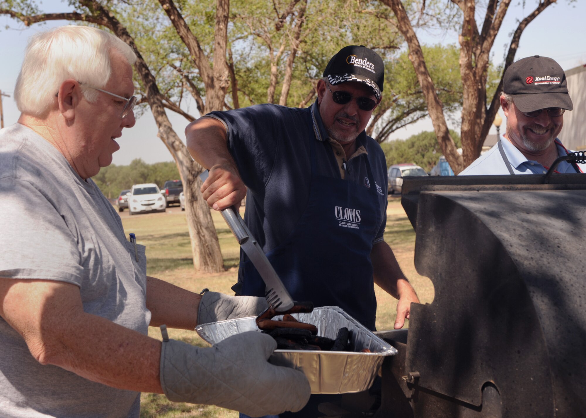 (left to right)Darryle Bender, Bender Dealership, David Essex, Xcel Energy and Jon Borne, Committee of Fifty, prepare hot dogs for the 22nd annual Cannon Appreciation Day at Unity Park, Cannon Air Force Base, N.M., Aug. 12, 2011.  The city of Clovis and local businesses sponsored the event to celebrate and honor the base with prizes, food and visit.  (U.S. Air Force photo by Senior Airman James Bell)