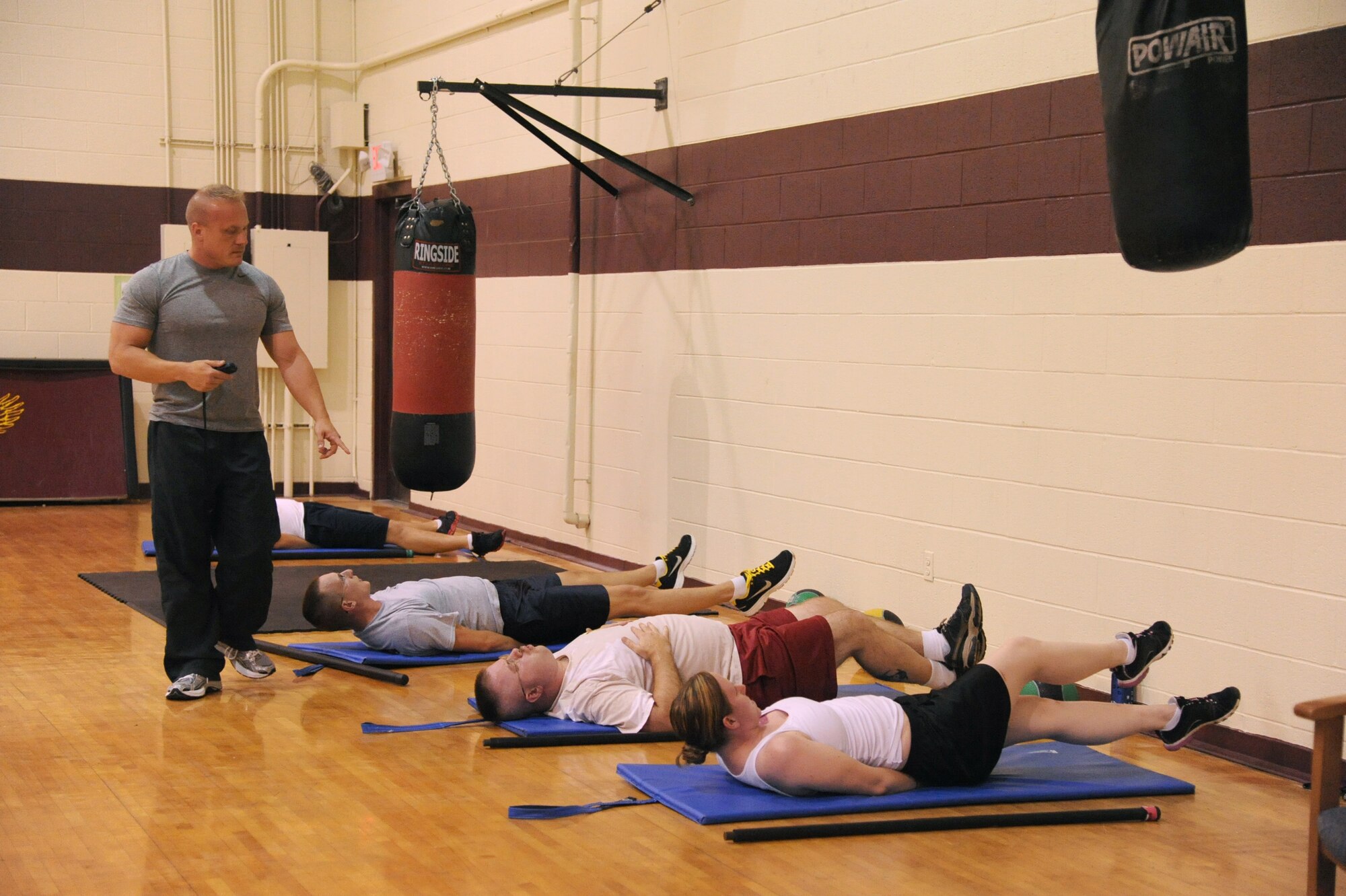 SEYMOUR JOHNSON AIR FORCE BASE, N.C.- Michael Unden, 4th Force Support Squadron military fitness specialist, observes students during a boot camp class here Aug. 15, 2011. Unden informs his students that slow, controlled movements allows for better contractions and quicker results for the abdominal and core muscles.  Unden is a native of Wichita, Kan. (U.S. Air Force photo by Senior Airman Whitney Lambert/Released)
