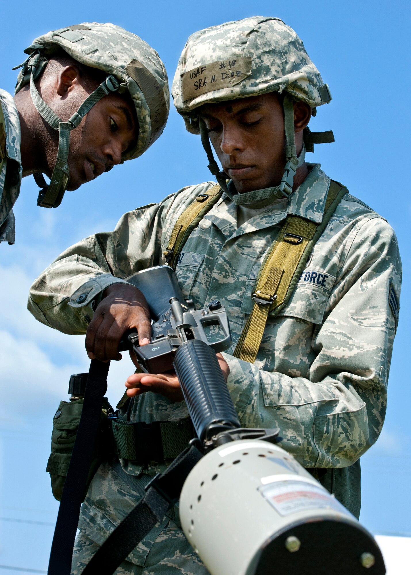 A staff sergeant checks Senior Airman Marcos Diaz’s, of the 96th Force Support Squadron, weapon before allowing him to enter the tent after a patrol during the Phase II exercise Aug. 10 at Eglin Air Force Base, Fla.  More than 100 Airmen braved black flag conditions (and rain) in chemical gear and gas masks to execute self-aid and buddy care, security and chemical attack avoidance missions.  The Phase II was part of a large week-long Operational Readiness Exercise on base.  (U.S. Air Force photo/Samuel King Jr.)