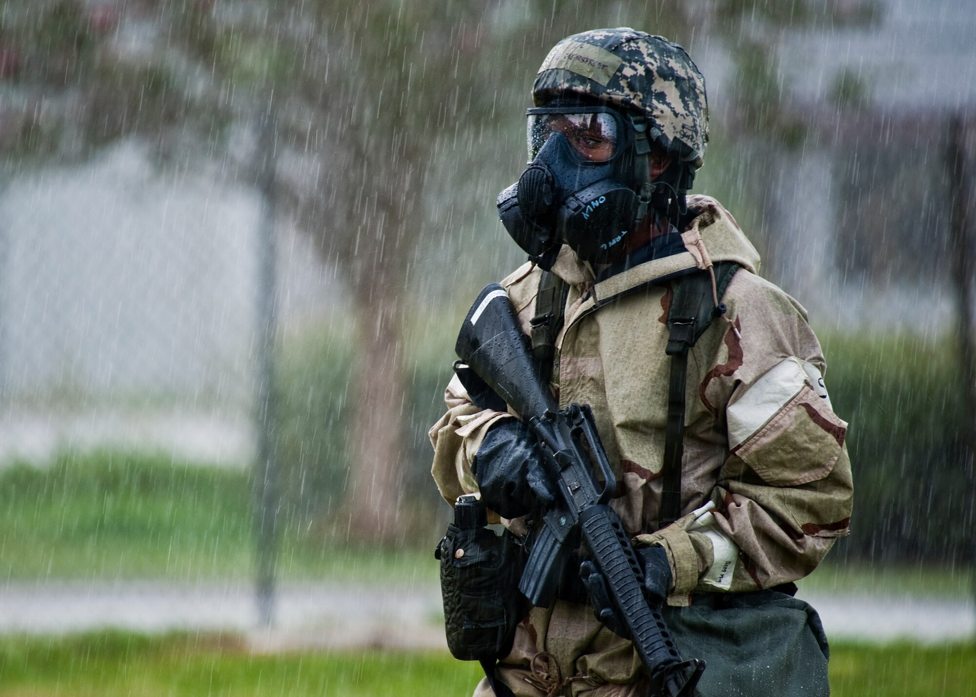 Airman 1st Class DeMichael Overstreet, of the 96th Civil Engineer Squadron, patrols his sector through a sudden rainstorm during the Phase II exercise Aug. 10 at Eglin Air Force Base, Fla.  More than 100 Airmen braved black flag conditions (and rain) in chemical gear and gas masks to execute self-aid and buddy care, security and chemical attack avoidance missions.  The Phase II was part of a large week-long Operational Readiness Exercise on base.  (U.S. Air Force photo/Samuel King Jr.)