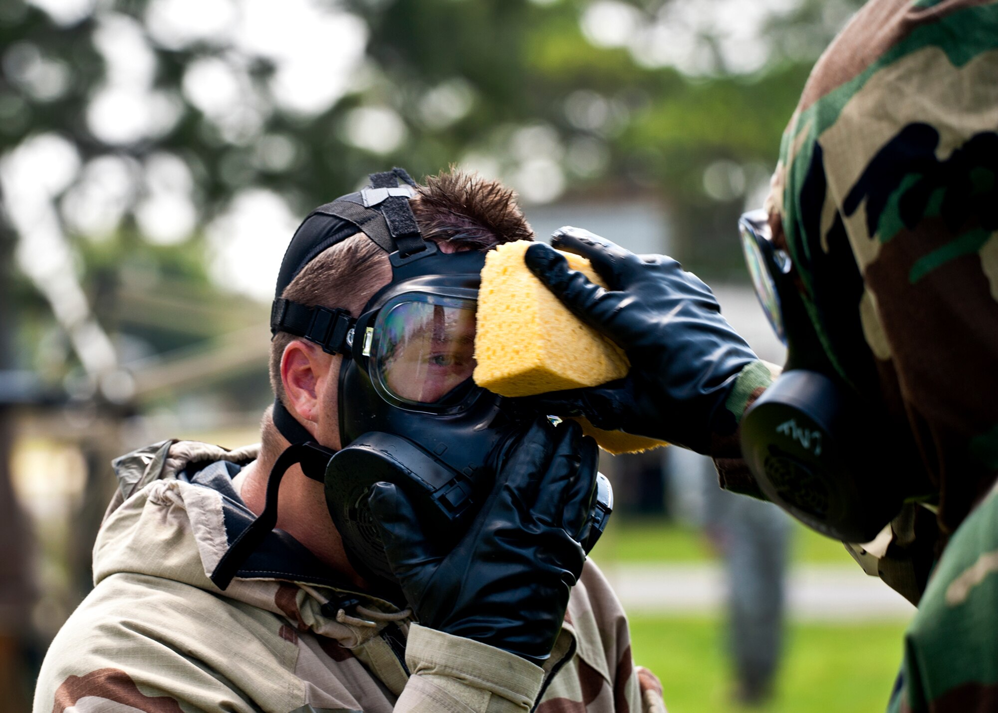 An Airman has his mask rinsed off while processing through the contamination control area  Aug. 12 Eglin Air Force Base, Fla.  More than 100 Airmen braved black flag conditions in chemical gear and gas masks to accomplish their missions.  The Phase II was part of a large week-long Operational Readiness Exercise on base.  (U.S. Air Force photo/Samuel King Jr.)