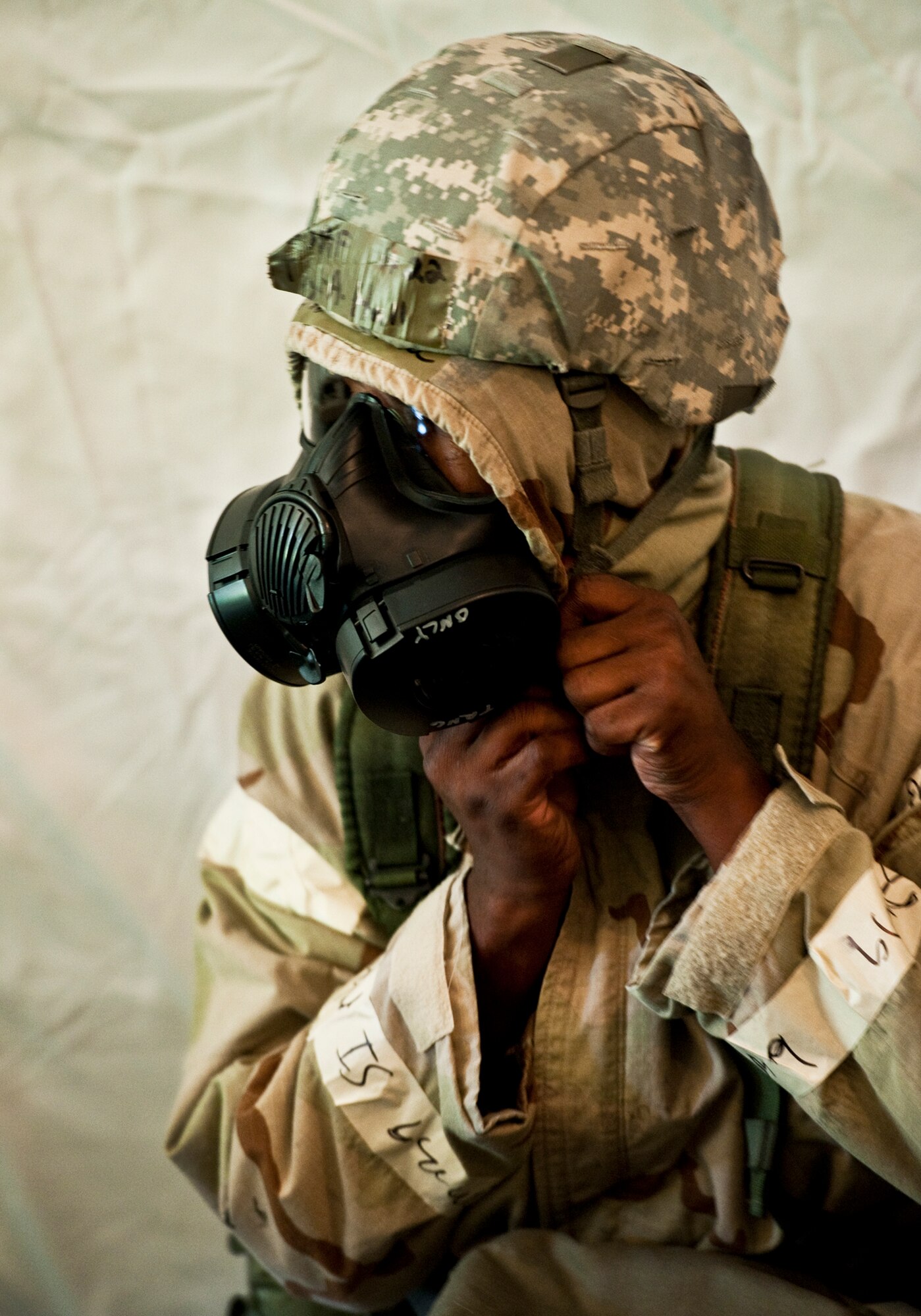 An Airman struggles to get his hood sealed quickly during a simulated mission oriented protective posture level 4 attack at the Phase II exercise Aug. 10 at Eglin Air Force Base, Fla.    More than 100 Airmen braved black flag conditions in chemical gear and gas masks to execute self-aid and buddy care, security and chemical attack avoidance missions.  The Phase II was part of a large week-long Operational Readiness Exercise on base.  (U.S. Air Force photo/Samuel King Jr.)