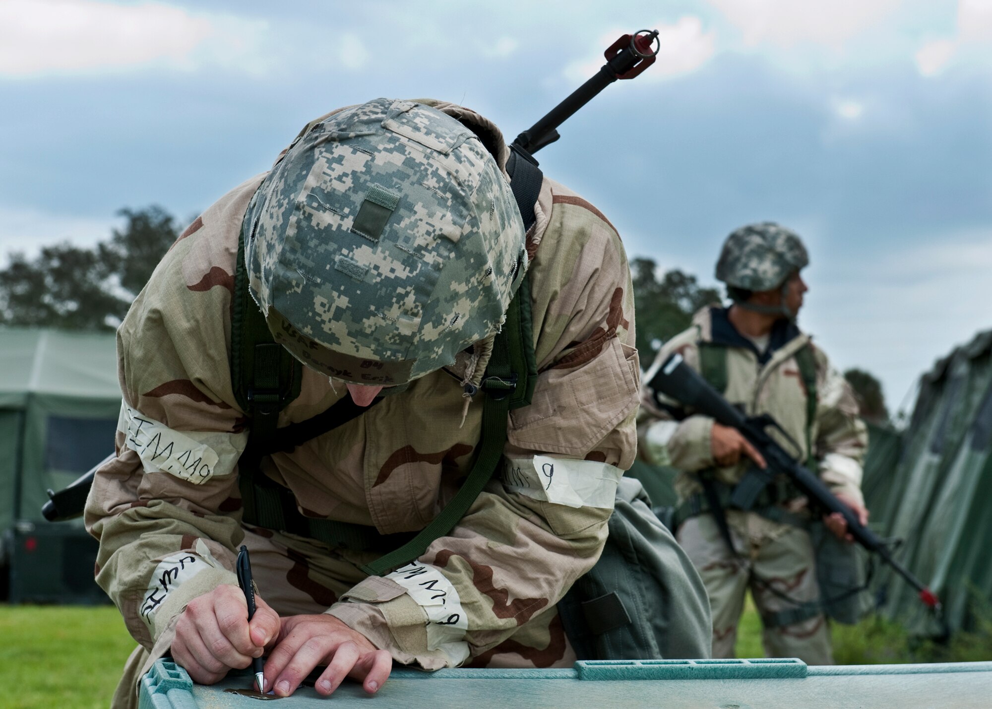 Senior Airman Erik Bernyk, 96th Civil Engineer Squadron, marks the date and time on the tape of the asset before covering it as part of contamination avoidance measures during the Phase II exercise Aug. 10 at Eglin Air Force Base, Fla.  More than 100 Airmen braved black flag conditions in chemical gear and gas masks to accomplish their missions.  The Phase II was part of a large week-long Operational Readiness Exercise on base.  (U.S. Air Force photo/Samuel King Jr.)
