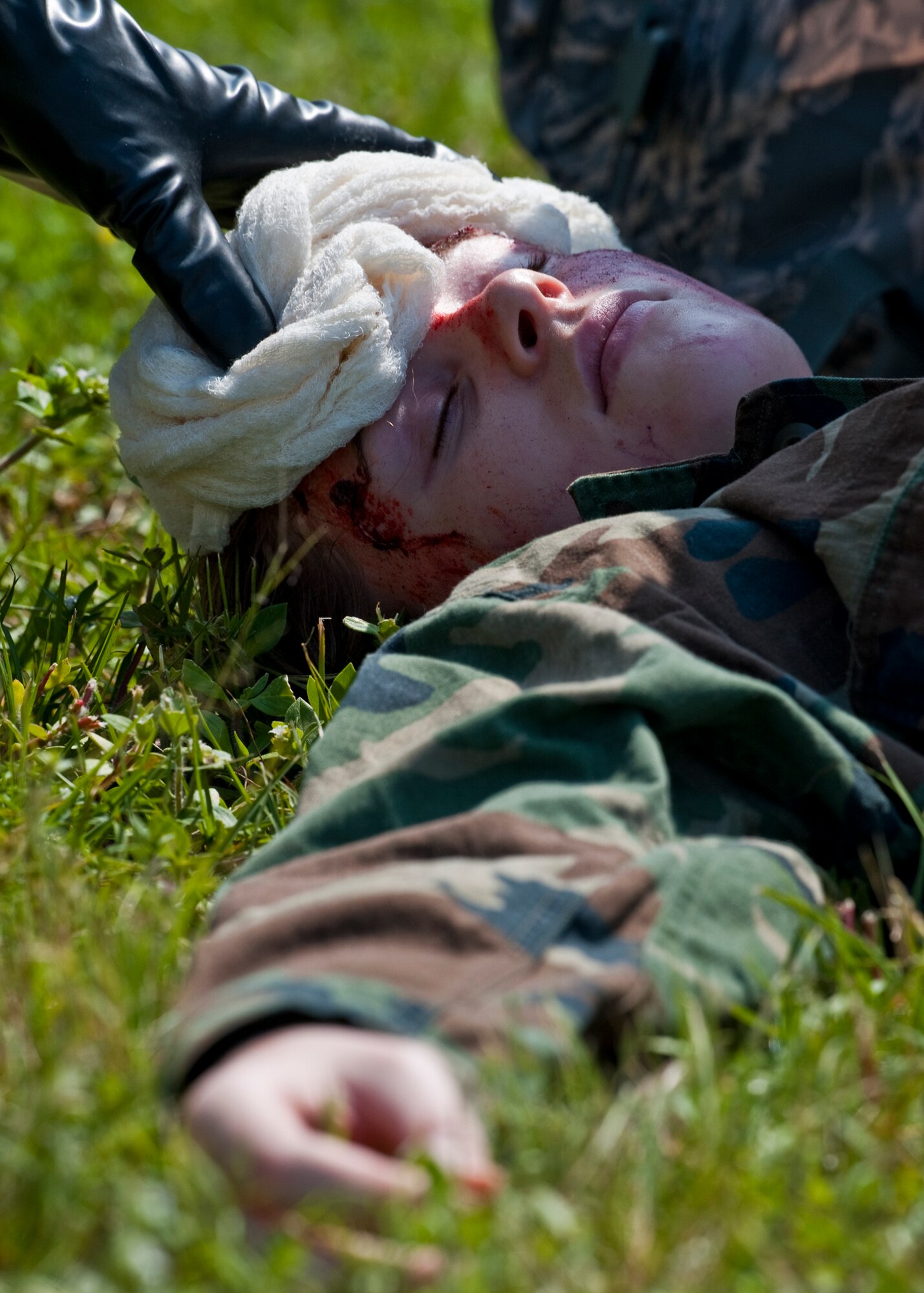 A simulated attack victim receives battlefield medical treatment at the Phase II exercise Aug. 10 at Eglin Air Force Base, Fla.  More than 100 Airmen braved black flag conditions in chemical gear and gas masks to execute self-aid and buddy care, security and chemical attack avoidance missions.  The Phase II was part of a large week-long Operational Readiness Exercise on base.  (U.S. Air Force photo/Samuel King Jr.)