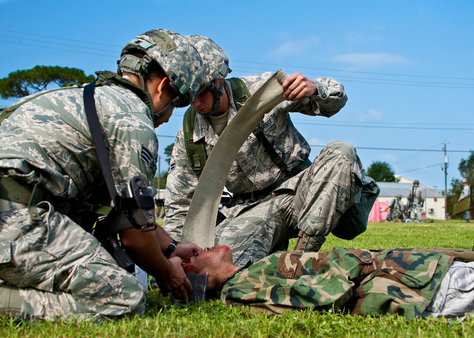 Groups of Airmen provide battlefield medical care to simulated attack victims at the Phase II exercise Aug. 10 at Eglin Air Force Base, Fla.  More than 100 Airmen braved black flag conditions in chemical gear and gas masks to execute self-aid and buddy care, security and chemical attack avoidance missions.  The Phase II was part of a large week-long Operational Readiness Exercise on base.  (U.S. Air Force photo/Samuel King Jr.)