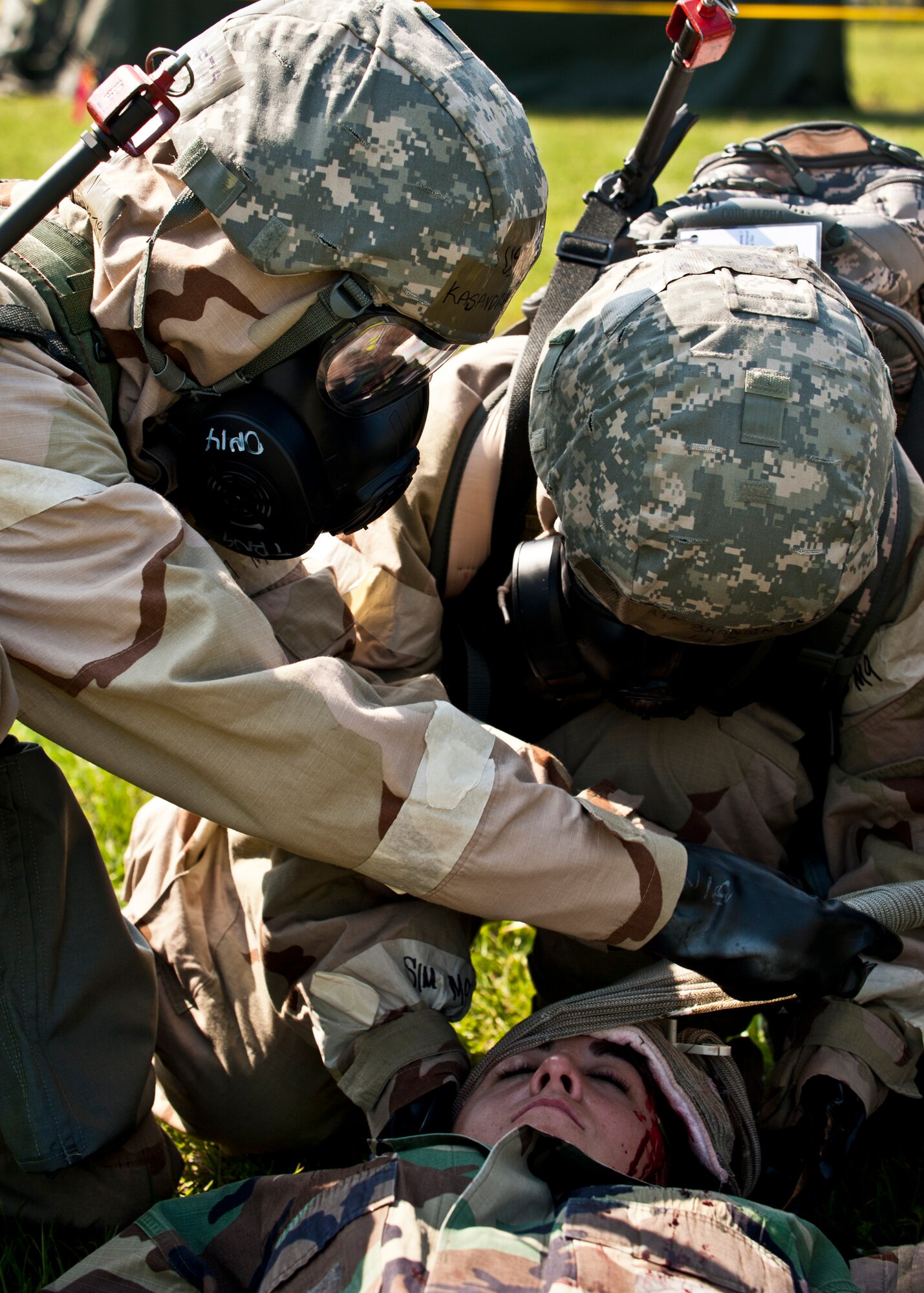 Airmen in full chemical gear and gas masks provide medical care to a simulated attack victim at the Phase II exercise Aug. 12 at Eglin Air Force Base, Fla.  More than 100 Airmen braved black flag conditions in chemical gear and gas masks to execute self-aid and buddy care, security and chemical attack avoidance missions.  The Phase II was part of a large week-long Operational Readiness Exercise on base.  (U.S. Air Force photo/Samuel King Jr.)