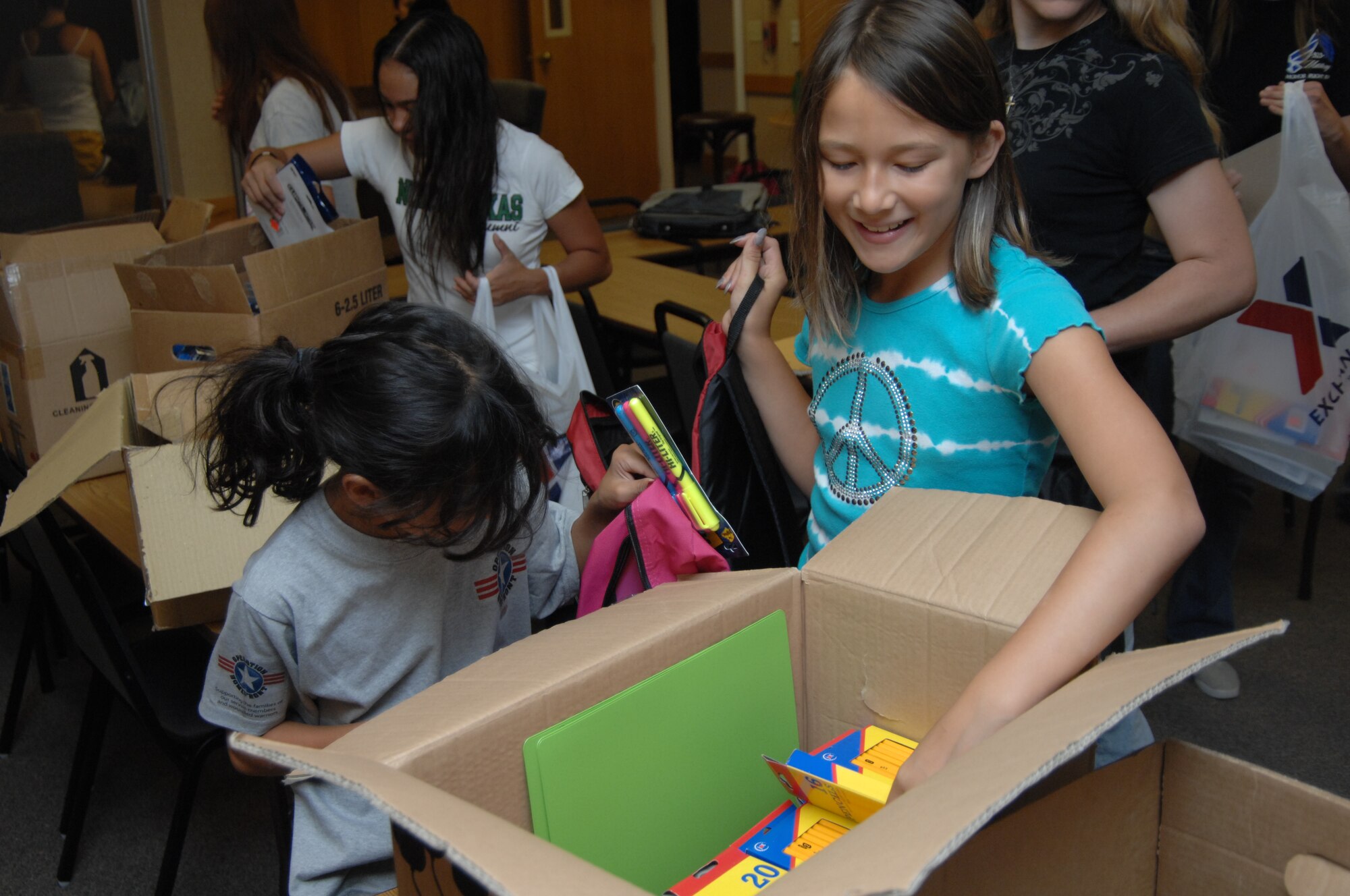 MOUNTAIN HOME AIR FORCE BASE, Idaho – Volunteers stuff backpacks with more than 60 different types of school supplies during Operation Homefront Aug. 13. Members of the Gunfighter community came out with their own children and stuffed more than 70 backpacks and 150 plastic bags. The mission of Operation Homefront is to provide emergency financial and other assistance to service members and families of wounded warriors. (U. S. Air Force photo by Senior Airman Benjamin Sutton)