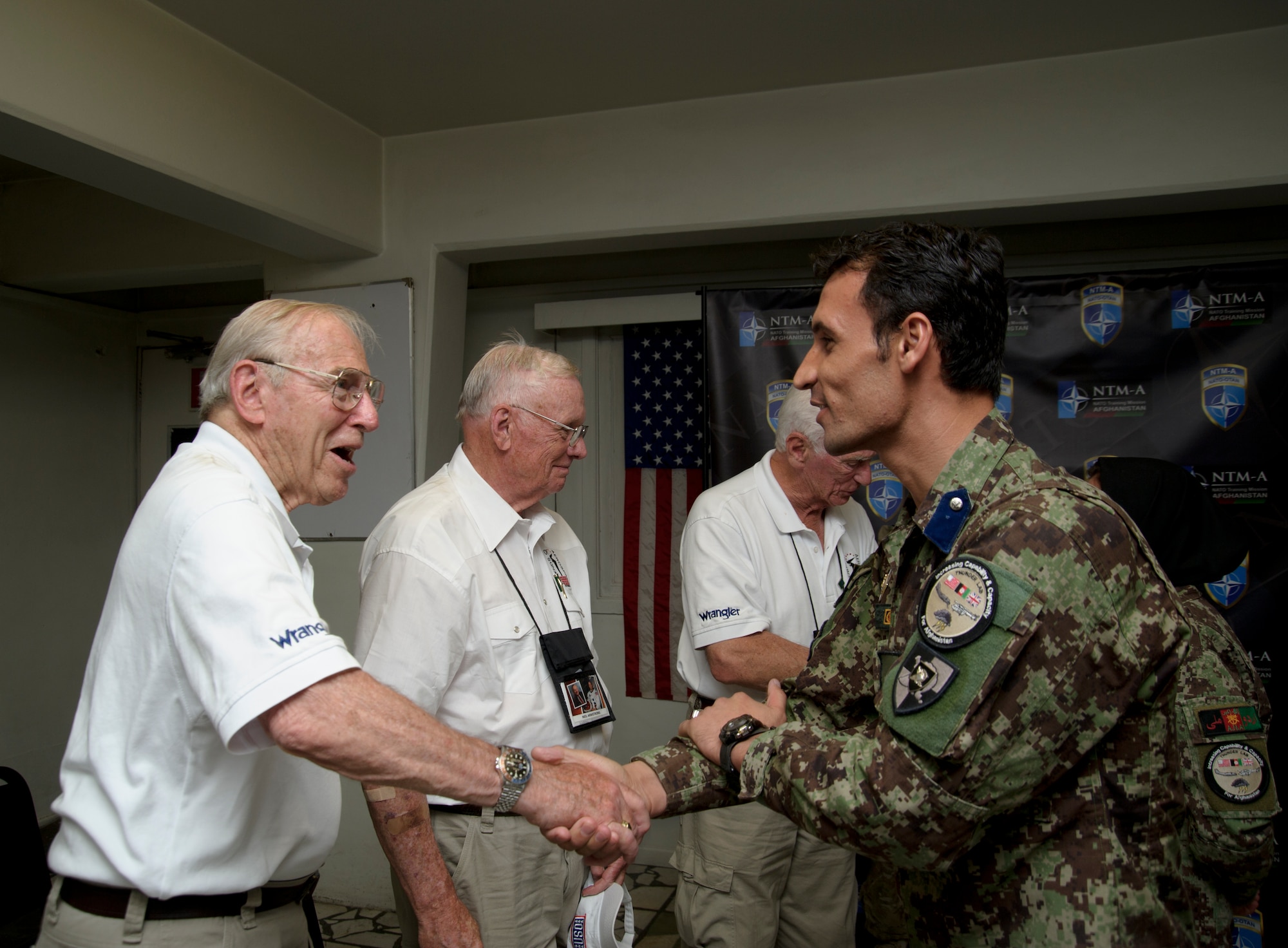 Astronaut Jim Lovell meets Afghan Air Force 2nd Lt. Khan Aghar, a pilot candidate, at Camp Eggers today as part of the base's United Service Organization tour with Astronauts Neil Armstrong (middle) and Gene Cernan also in attendance. Armstrong, Cernan and Lovell spoke with a small group of AAF pilot candidates and aviation officers from the 438th Air Expeditionary Wing, during a meeting held between the living legends of American space exploration and the future of Afghan aviation. (U.S. Air Force photo by Staff Sgt. Matt Smith)  