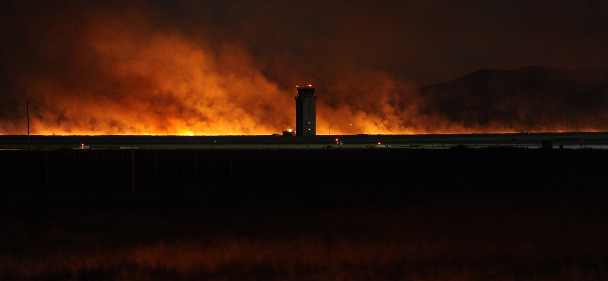 A brush fire believed to have been started by a lightening strike that occurred Sunday evening burns along the fence line at Mountain Home Air Force Base, Idaho, Aug. 15, 2011. More than 20 vehicles and nearly 60 firefighters from the base, the city of Mountain Home and Grandview fire departments, along with the Bureau of Land Management worked together to fight the grass fire. (U.S. Air Force photo by Staff Sgt. Gina Chiaverotti-Paige)