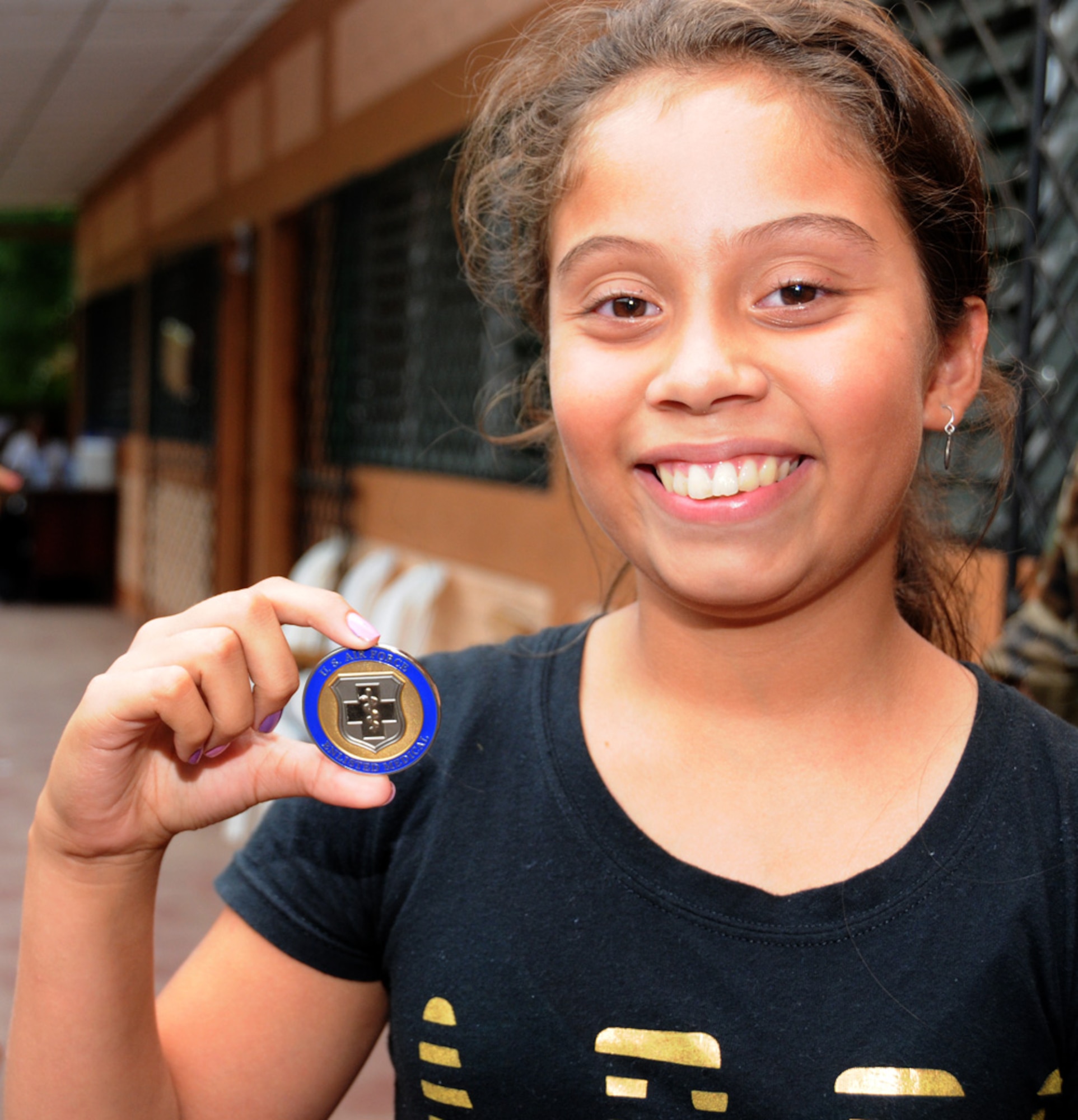 SEBACO, NICARAGUA -- Antonella Espinoza, a local 12-year-old student, shows off the coin she received here Aug. 10, 2011 for volunteering as a transplator during the Medical Readiness Exercise, or MEDRETE. Espinoza came to the MEDRETE site to be seen for her allergies and ended up staying on to help the staff communicate with their patients more effectively. (USAF photo by Senior Airman Meredith A. H. Thomas, 916 ARW/PA)